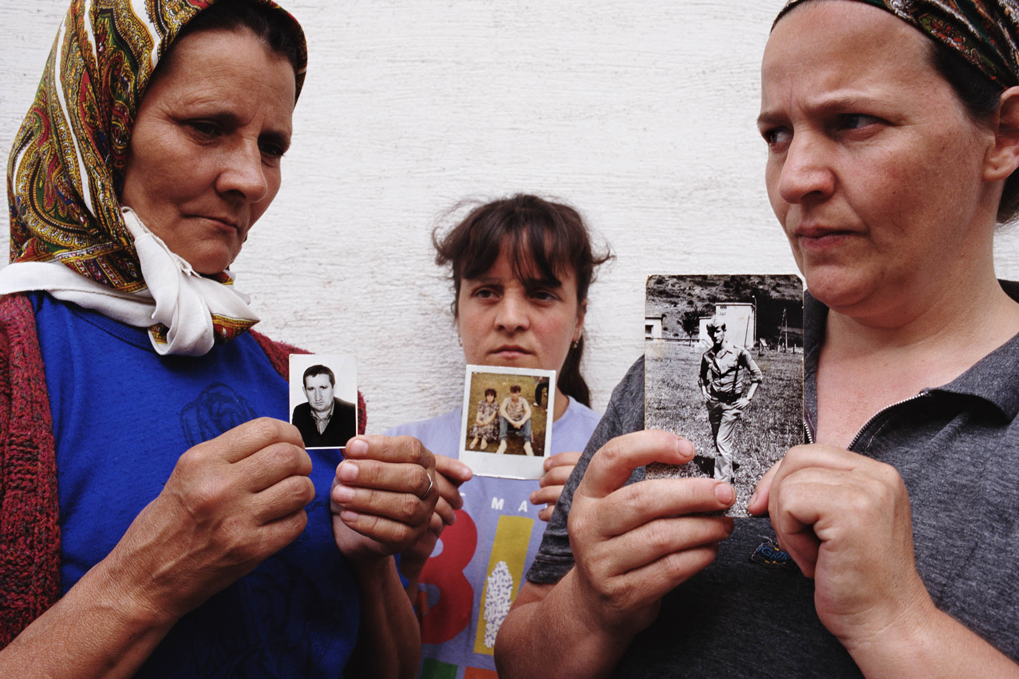Women holding pictures of their husbands after the Srebrenica massacre in 1996