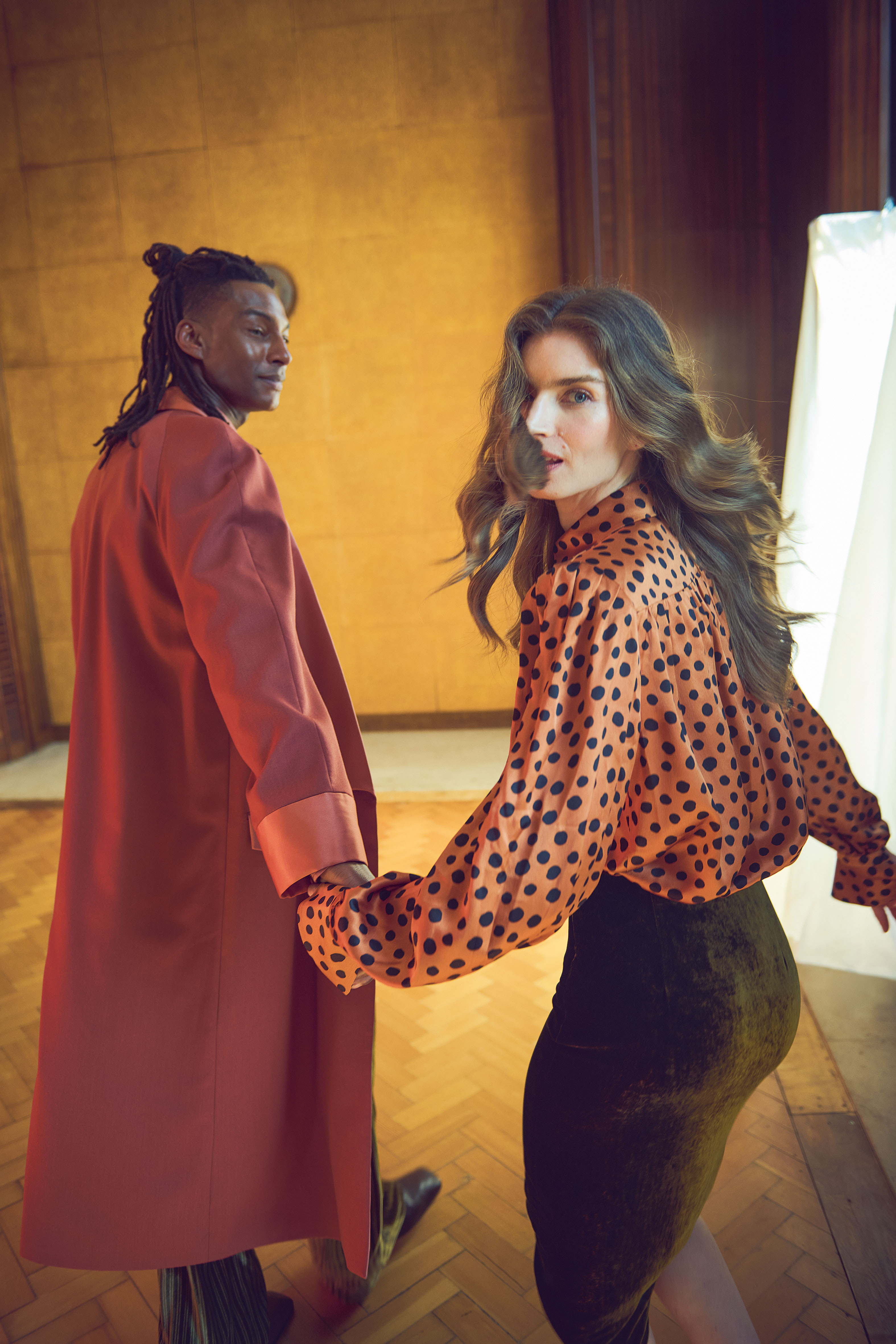 Ty wears coat, striped trousers and shoes all by Amiri; and Maddy wears polka-dot blouse, velvet skirt and shoes all by Valentino