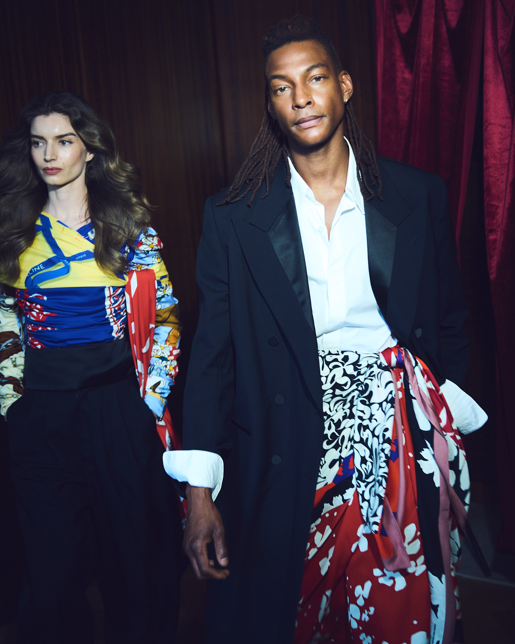 Maddy wears drape top and tux trousers all by Celine; Ty wears Coat, shirt, sarong-skirt and trousers all by Dries Van Noten