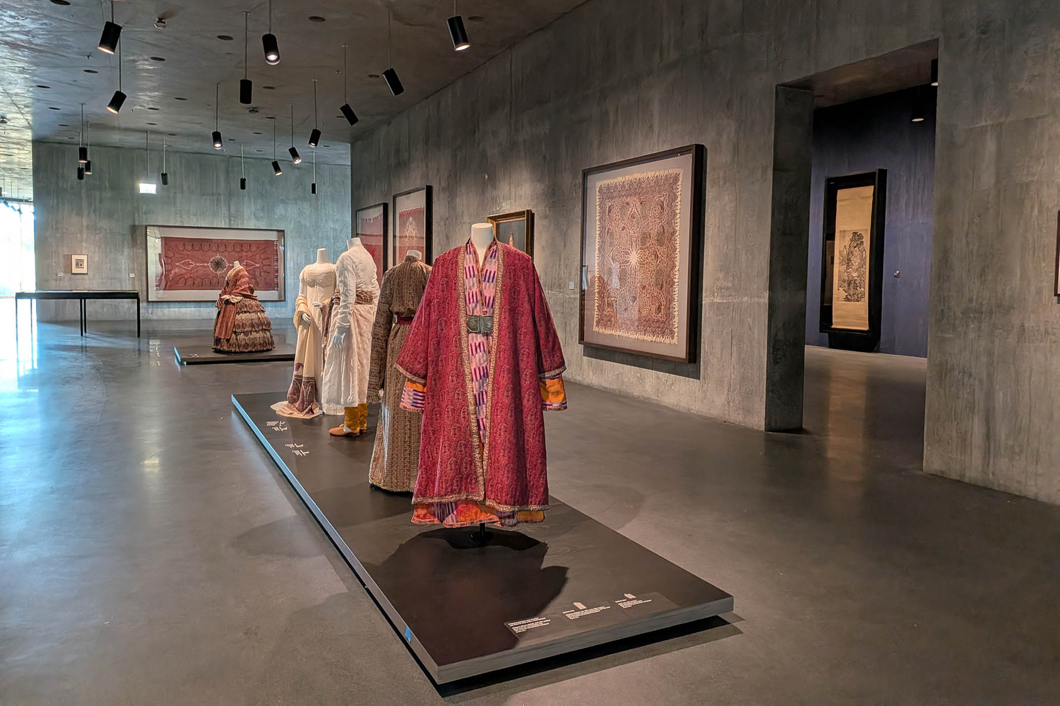A Victorian hoop dress is installed alongside the Kashmiri textiles that inspired it in one room