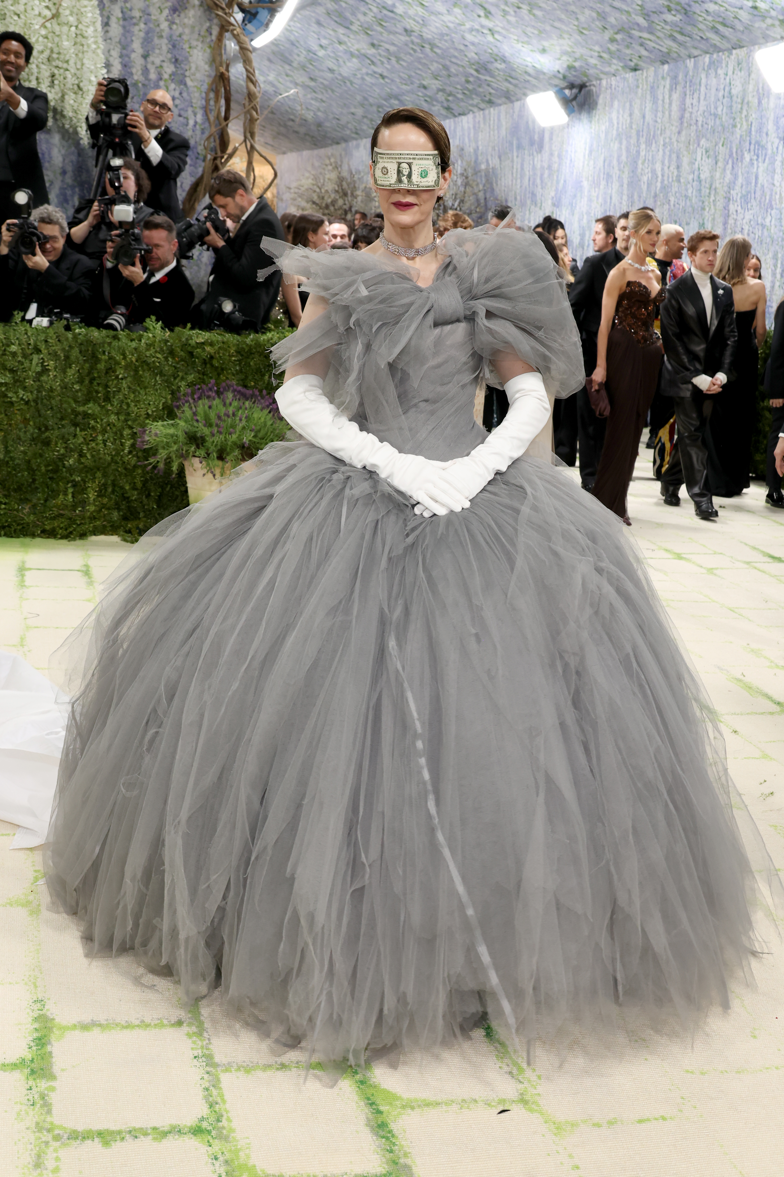 The final word goes to Sarah Paulson who used her appearance on the carpet to make a pointed statement about the 1%. Her “blinded by money” mask and grey tulle gown by Matières Fécales was a reflection of the greed and corruption that comes with extreme power.