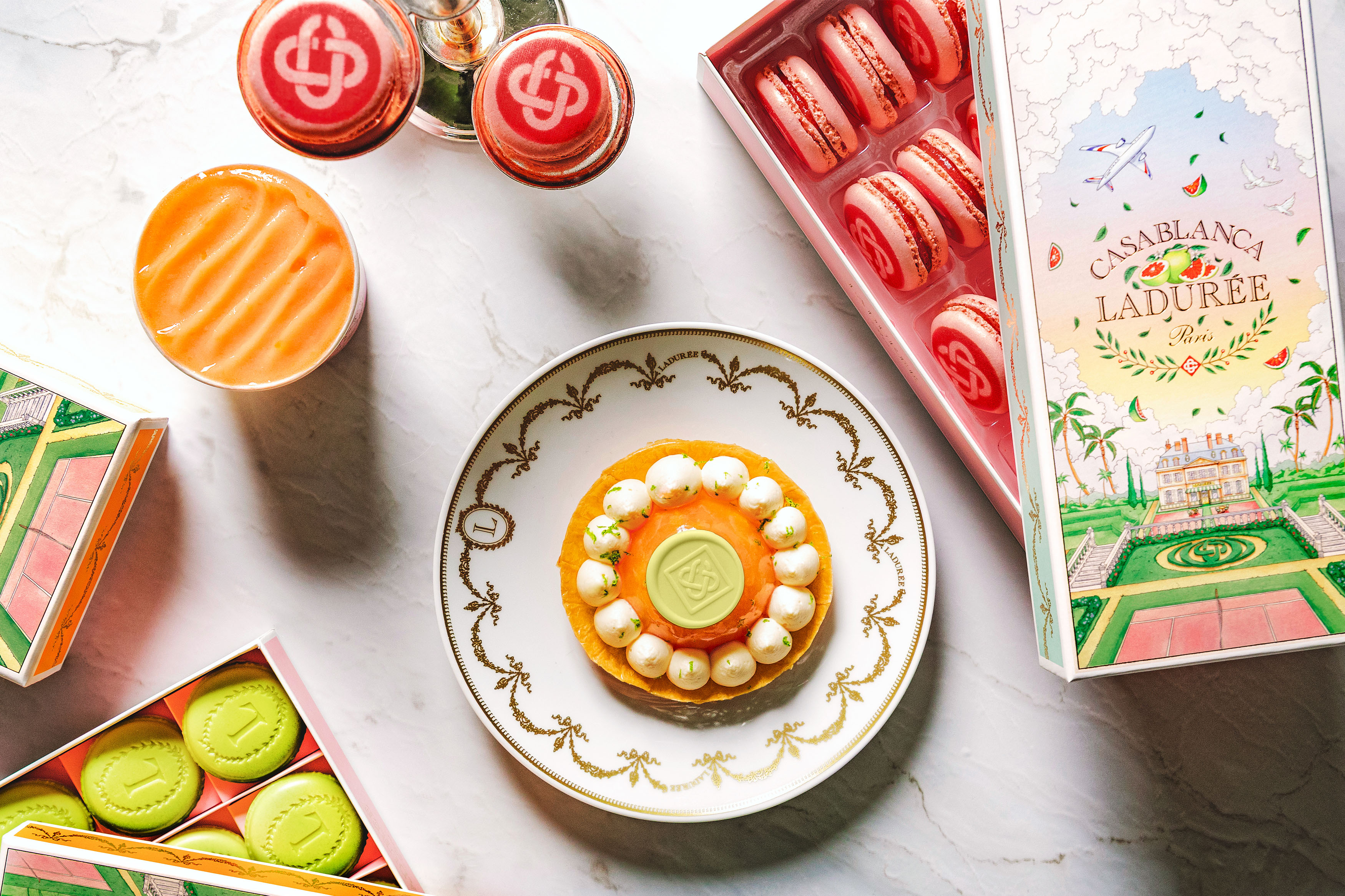 Sweet Deal Casablanca and Maison Ladurée have launched a collaboration blending summer ready-to-wear, accessories and pastel hued pomelo and mint macarons. “As someone who grew up in Paris, Ladurée has always felt like a true institution to me” noted Casablanca Founder and Creative Director Charaf Tajer, “There’s a natural synergy between our two worlds: a shared attention to detail, a classic yet colorful palette, and above all, an appreciation for beauty and joy” he said. At the heart of the collaboration is a central motif, a scene of a chateau nested within a French garden, framed by tennis courts and palm trees which flows through the entire collection. Highlights include embroidered crochet bags, T-shirts and printed silk shirts. Ladurée gift box from £44, Casablanca capsule from £160–£770, Casablanca