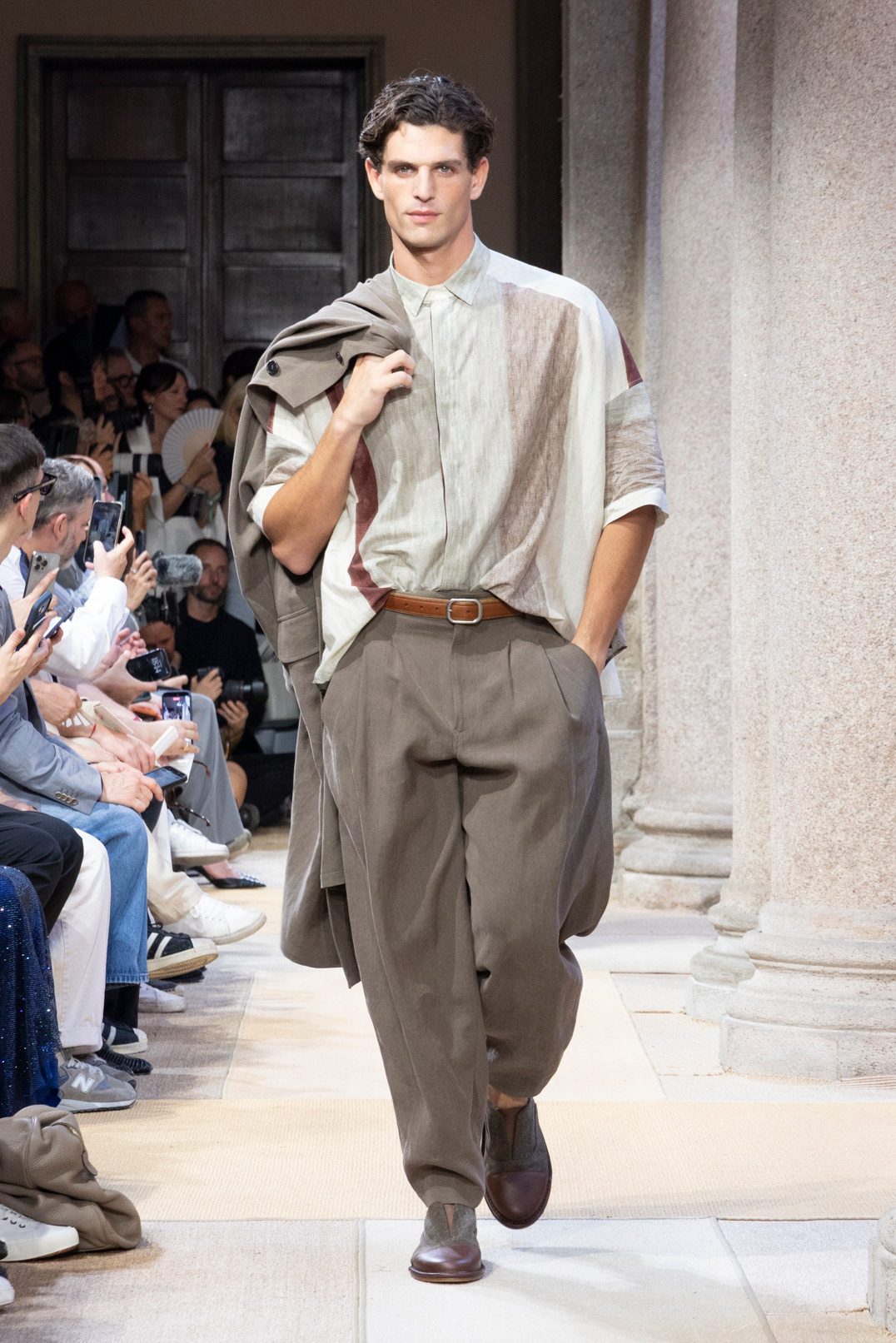 GIORGIO ARMANILeo Dell’Orco captured the spirit of the Mediterranean with his SS27 collection for Giorgio Armani. Shown alfresco in the courtyard of Palazzo Orsini – the former home of the late designer, who passed away last year aged 91 – the space was decorated with rattan mats and Moroccan cushions. Following the show, the gates to the garden were opened for a cocktail party as the sun set on Milan fashion week. The collection’s colour palette drew on the white of sun-scorched stone, earthy sun-drenched shades and tones of market spices. Flowing shirts were shown alongside relaxed safari jackets and a slimmer but still fluid trouser. Heatwave-friendly fabrics, woven from natural fibres like linen, cotton and shantung, looked cool in more ways than one as temperatures in the Italian capital crept up to 38C. Dell’Orco said “I believe that in menswear it is essential to return to researching and innovating materials.” Also shown was the women’s cruise collection, the first designed by Armani’s niece, Silvana Armani.