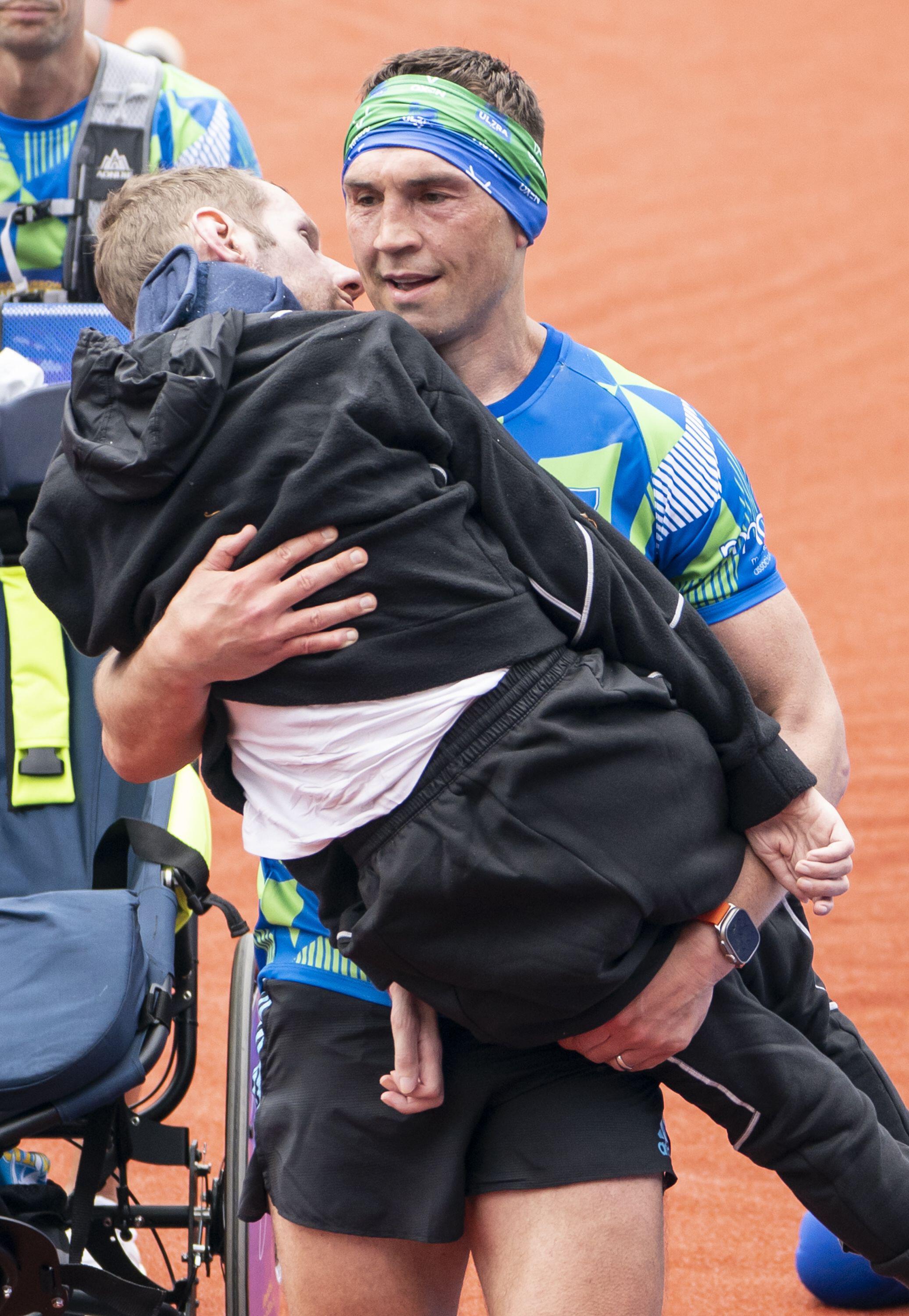 Kevin Sinfield carries his great friend over the finish line of the inaugural Rob Burrow Leeds Marathon in 2023