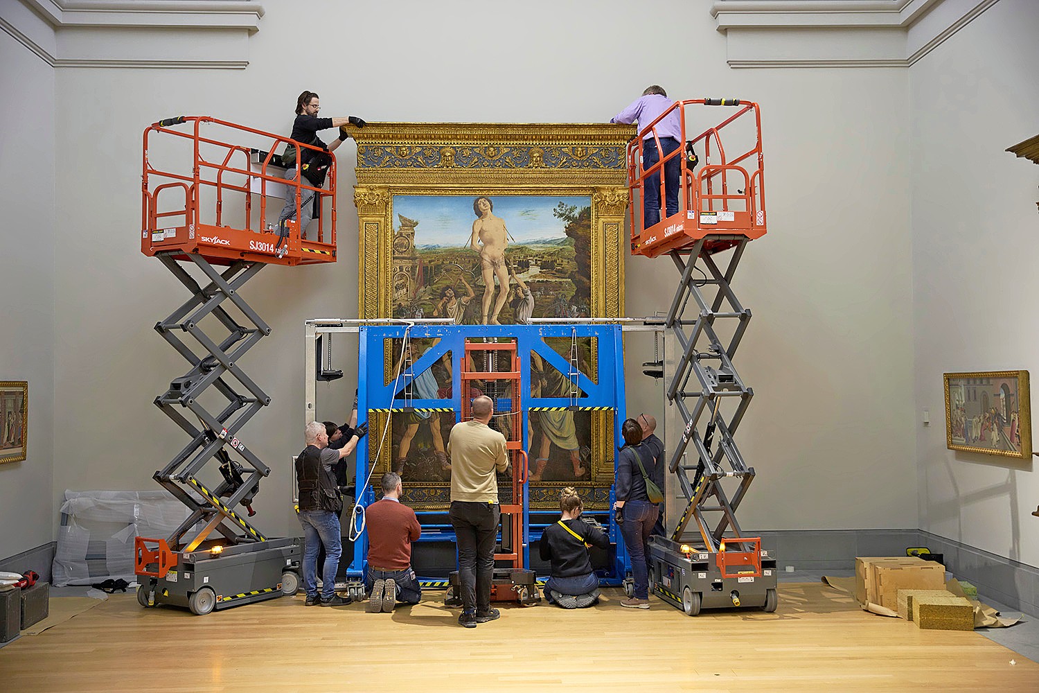 Gallery technicians at work on The Martyrdom of Saint Sebastian by Antonio del Pollaiuolo and Piero del Pollaiuolo
