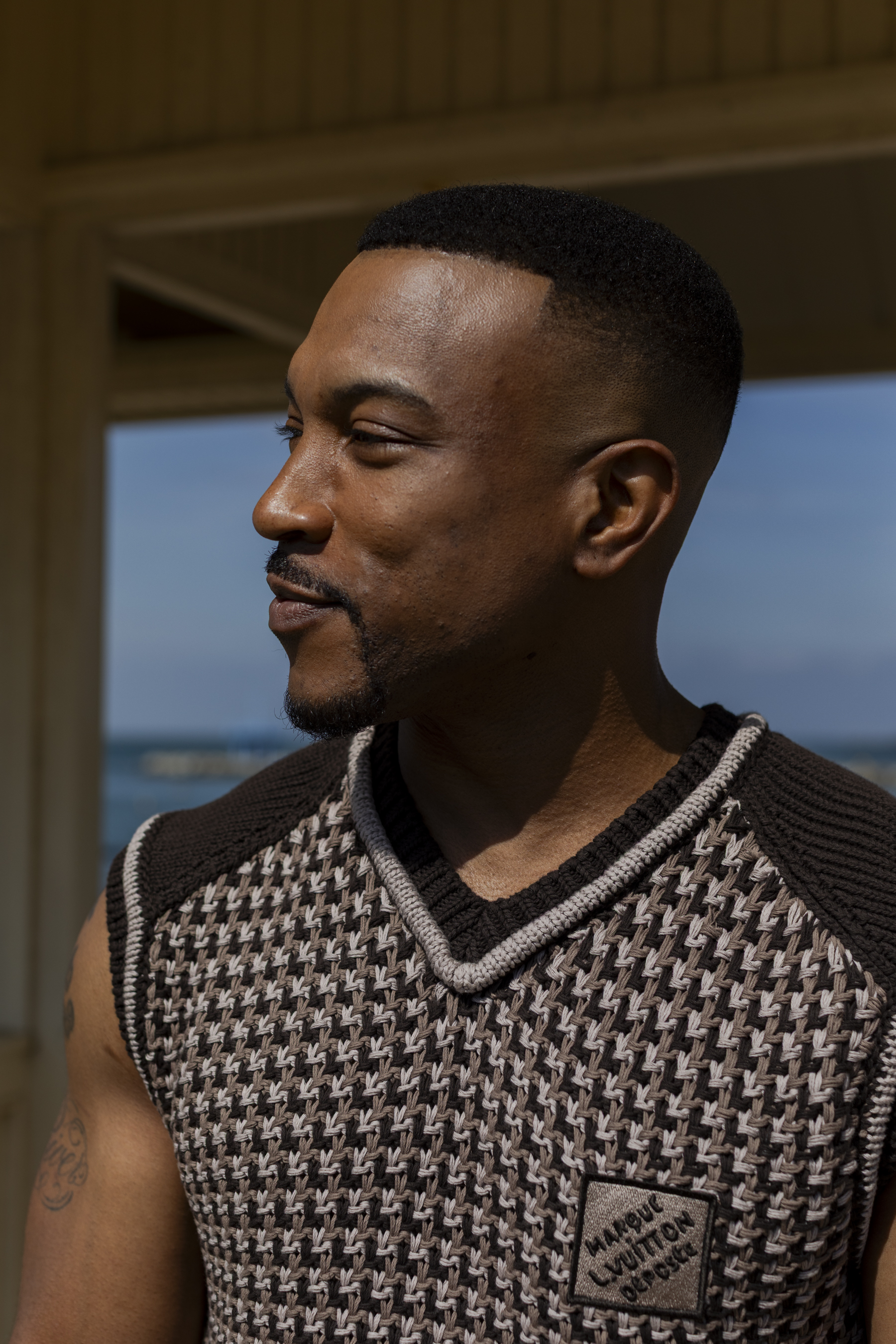 Ashley Walters wears jacquard vest and monogram denim trousers both by Louis Vuitton, and brogues by Craig Green + Grenson