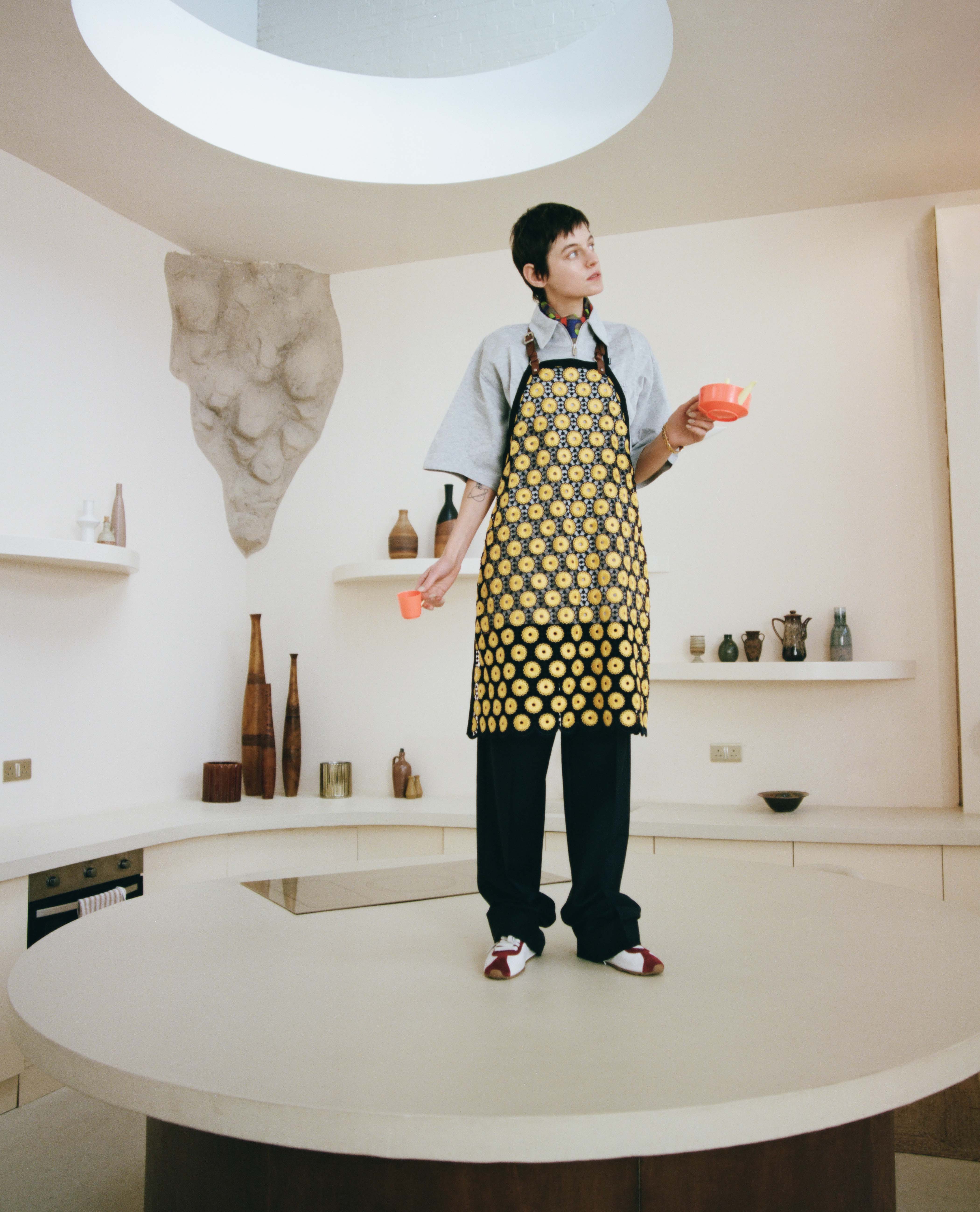 Apron, knitted polo, silk scarf and trainers, all by Miu Miu; watch by Cartier