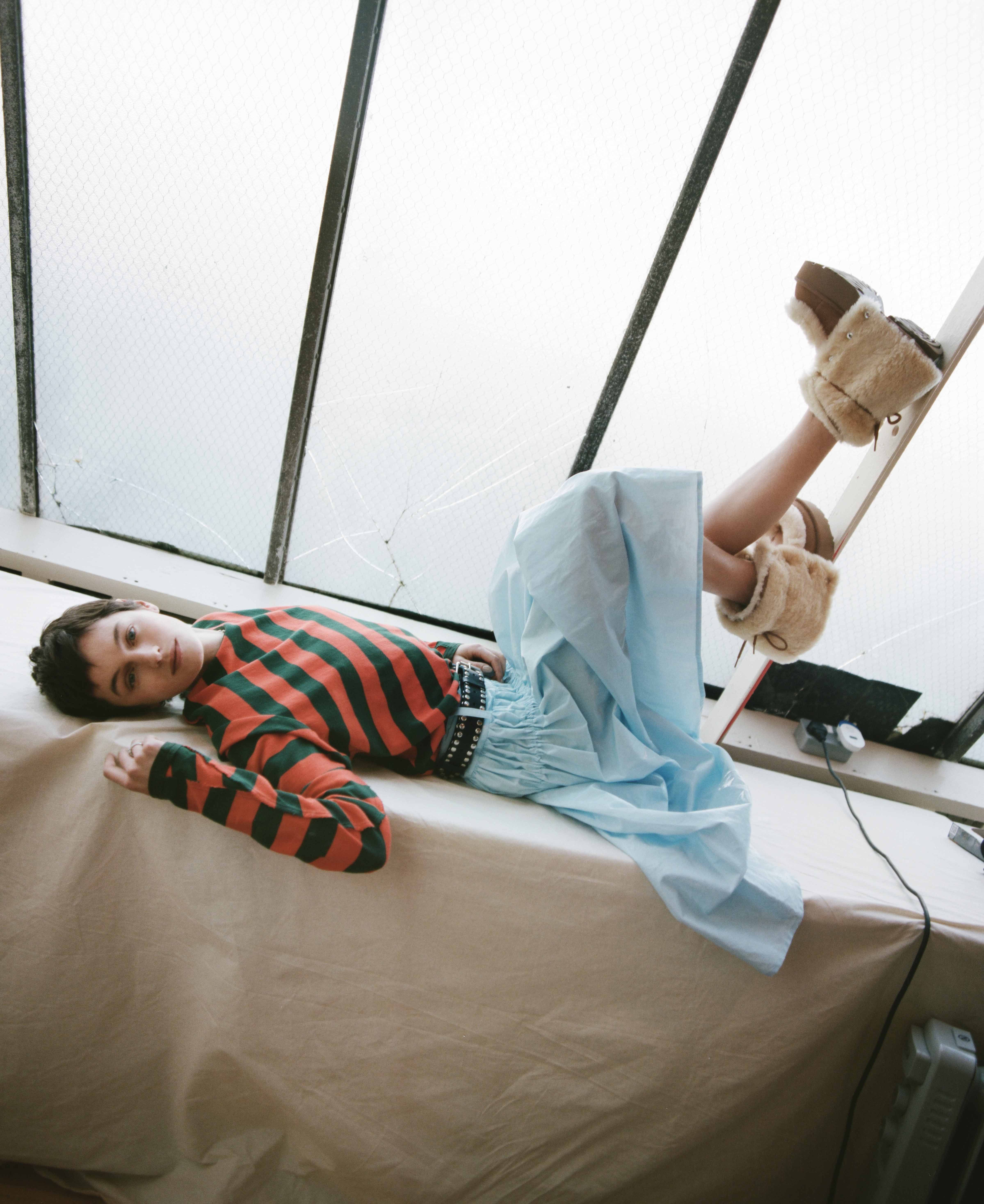 Top, skirt and belt and Uggs, all by Talia Byre; necklace and rings by Cartier
