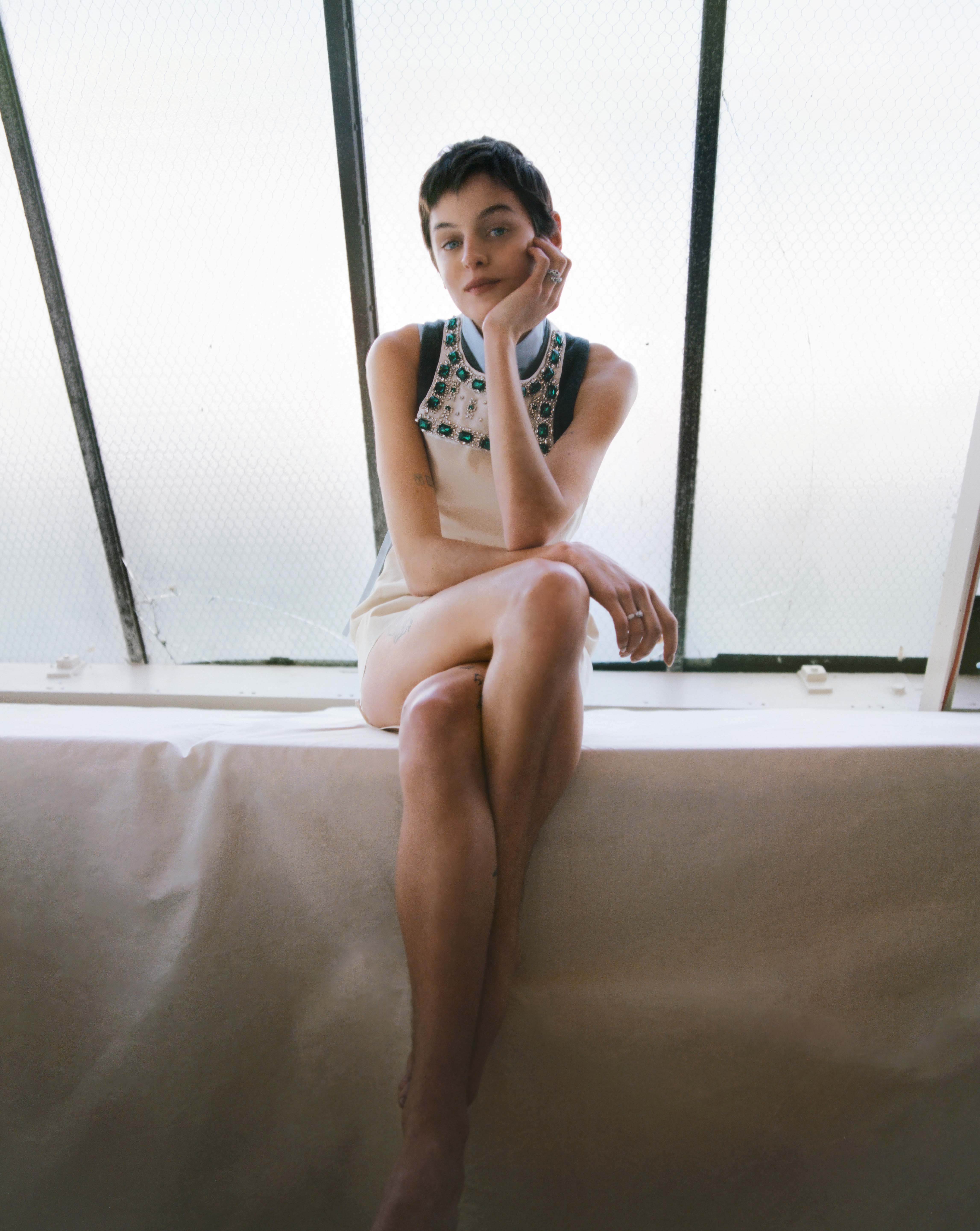 Embellished dress, vest and sleeveless shirt, all by Miu Miu; earrings and rings by Cartier