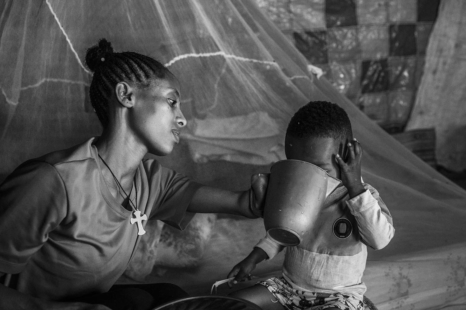 Yangus, a 24-year-old who lost part of her left arm when war broke out, feeds her two-year-old son in the Tigrayan city of Shire in April 2024
