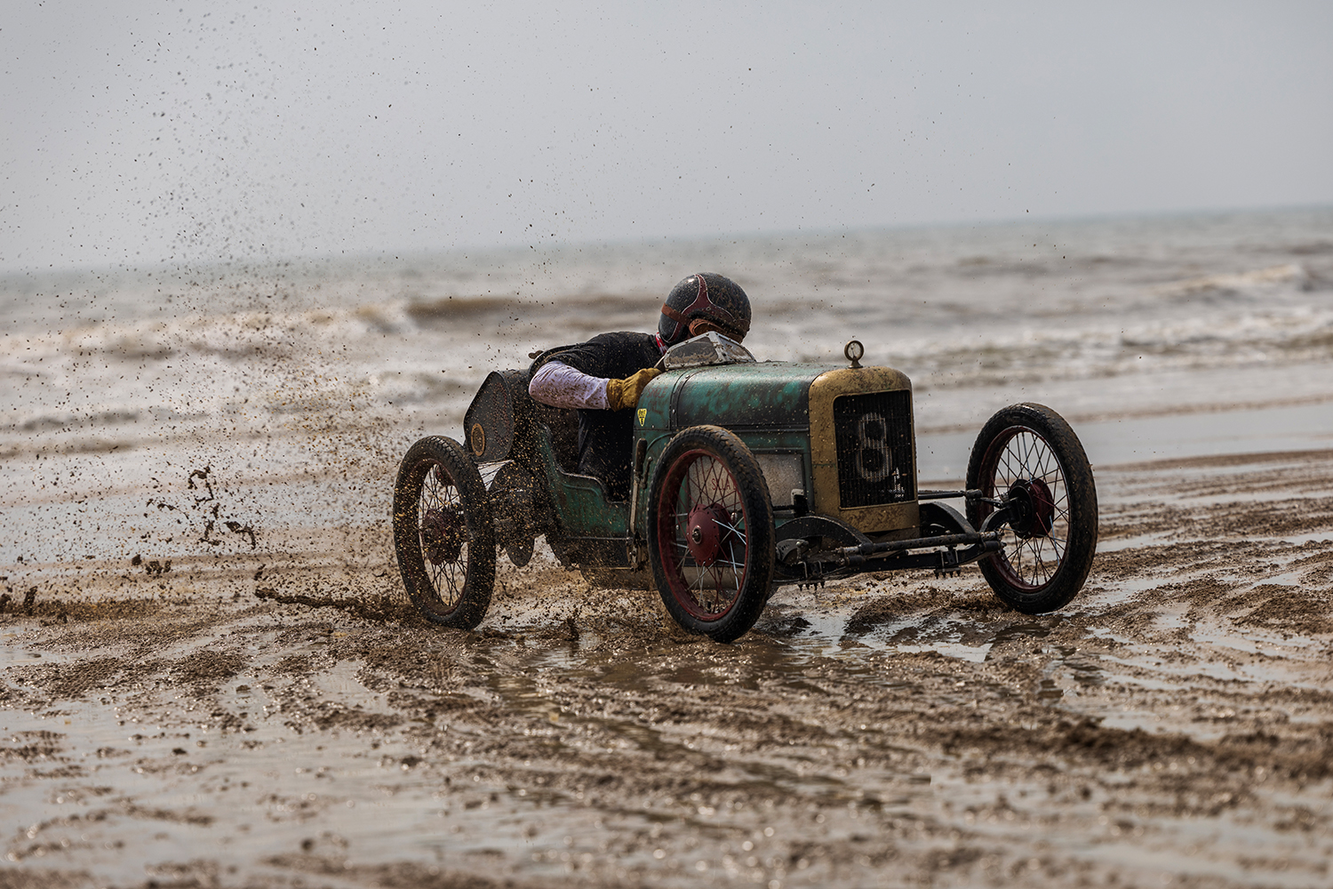 A vintage cyclekart tries not to skid into the surf.