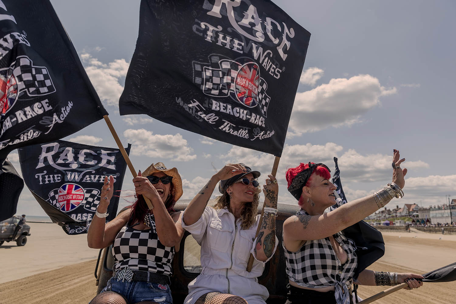 From left, Jules Naddie, Georgie Rae and Harriet Addams fly the flag