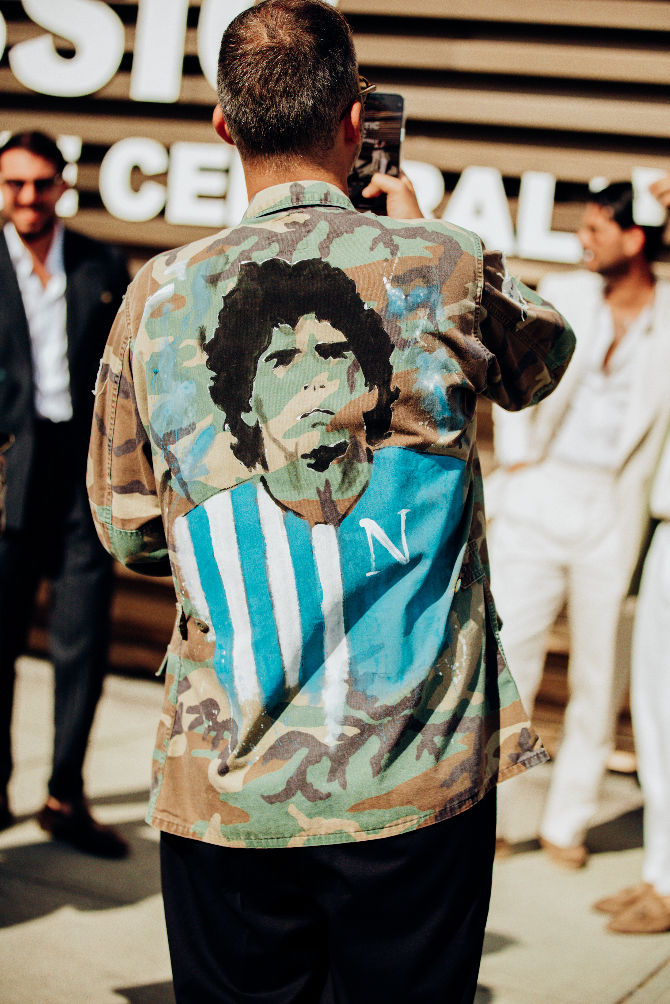 A show-goer wearing a hand-painted vintage jacket featuring footballer Maradona