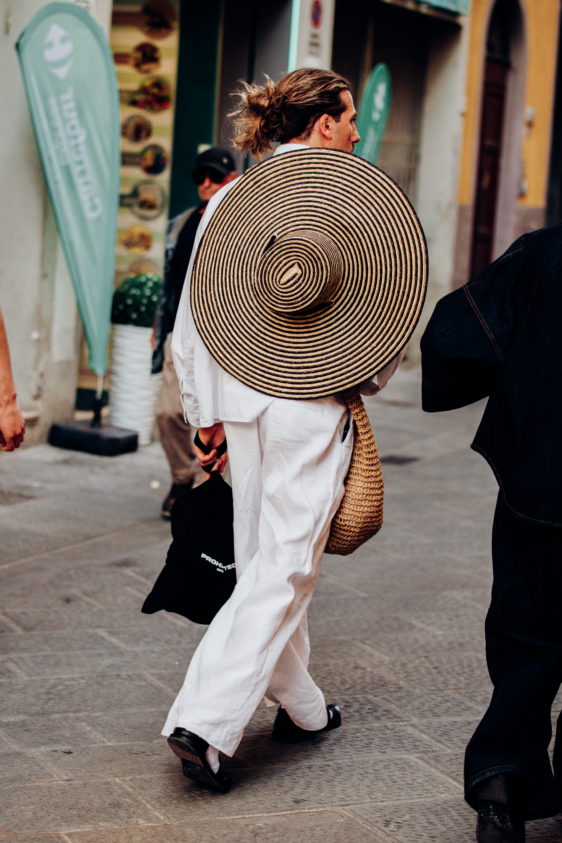 Dressing for the extreme heat in white with a wide-brim straw hat