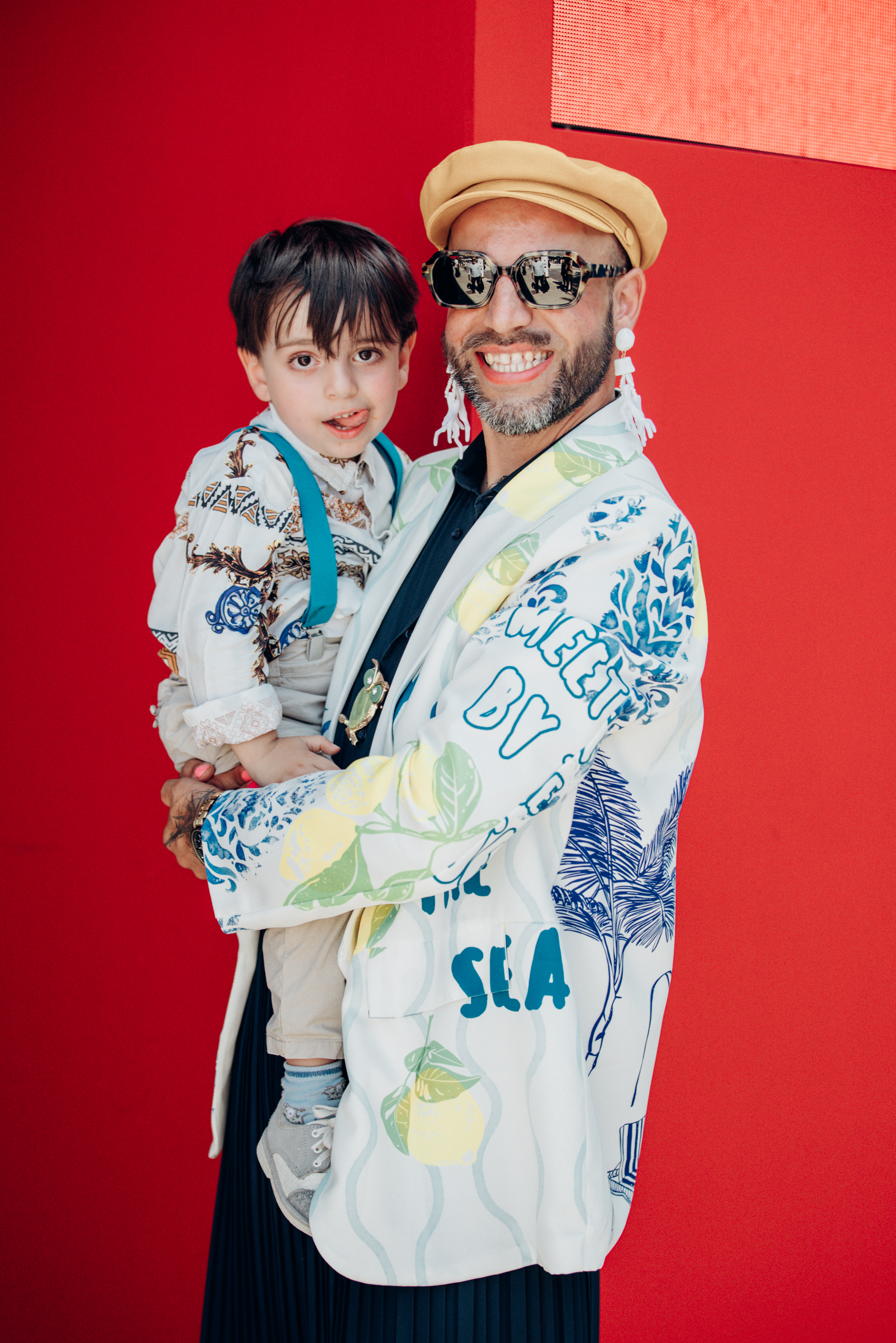 Daniele Lomio, influencer, with his son Enea, wearing Classe77 blazer and statement earrings