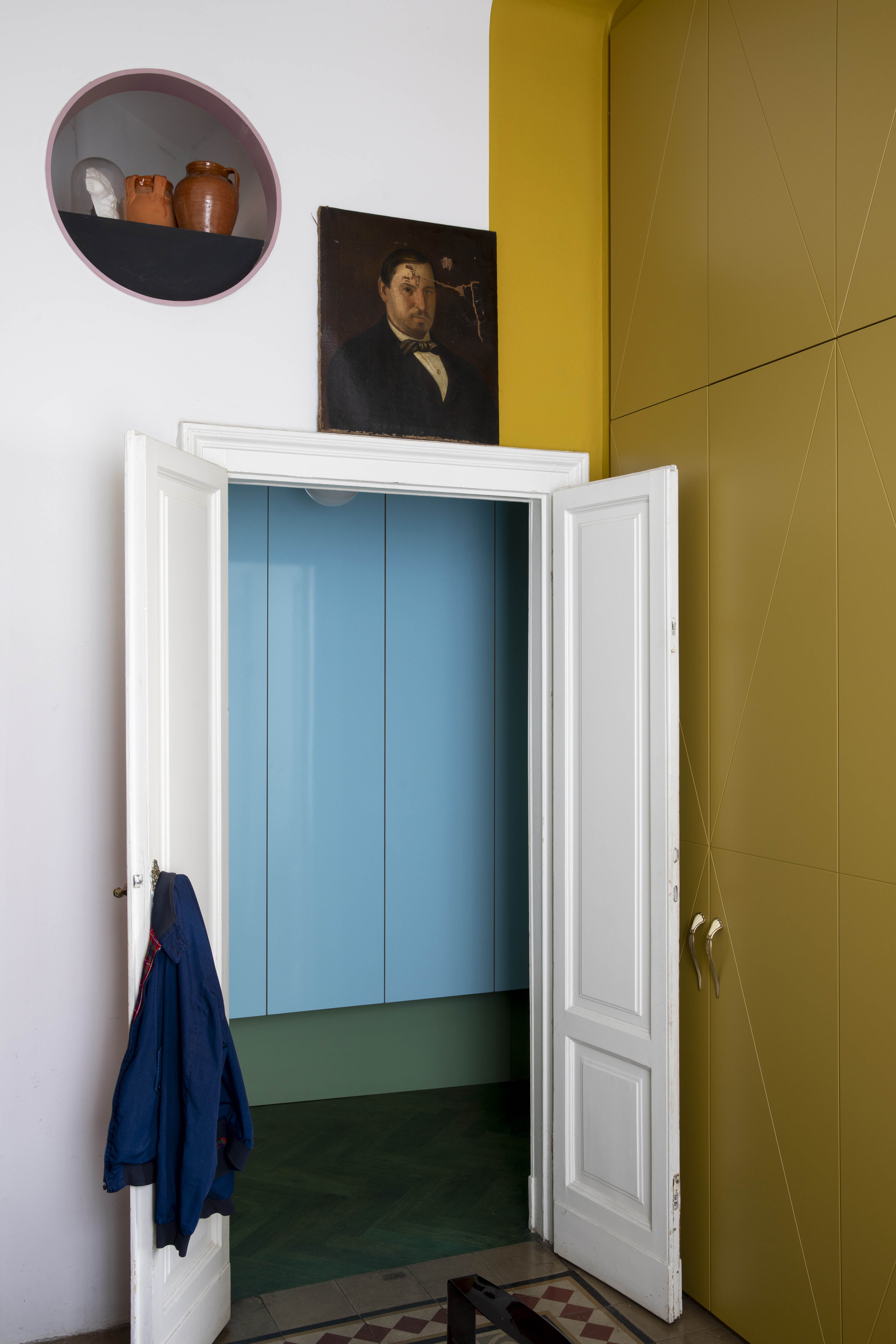 Trompe l’oeil artwork, strong colours and smart storage in a hall