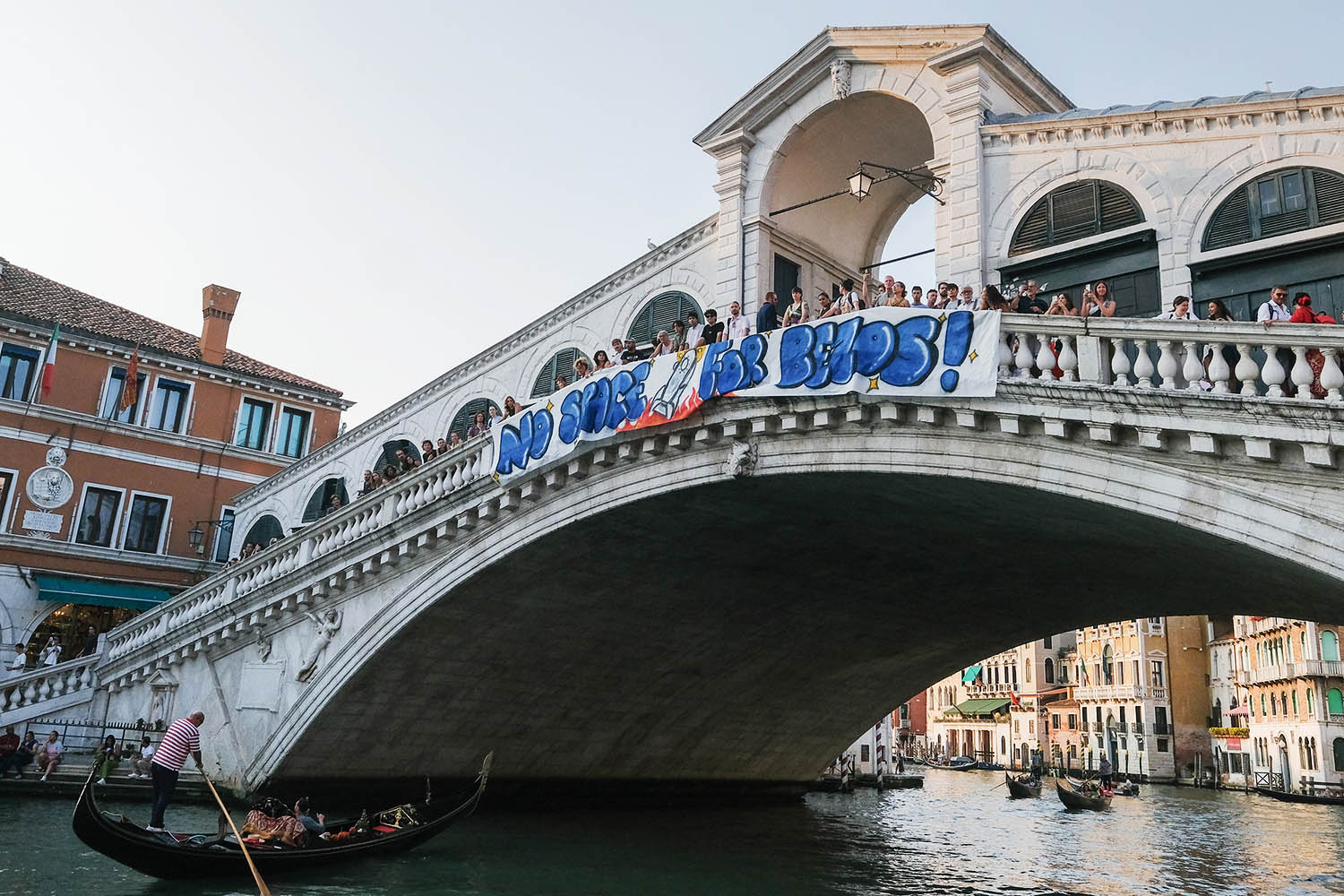 Activists from No Space For Bezos display a banner on the Rialto Bridge