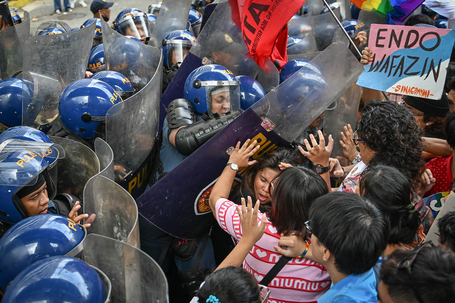 LGBTQ community clash with the police at the start pride protest held in support of a campaign to pass an anti-discrimination bill in Manila on 26 June.