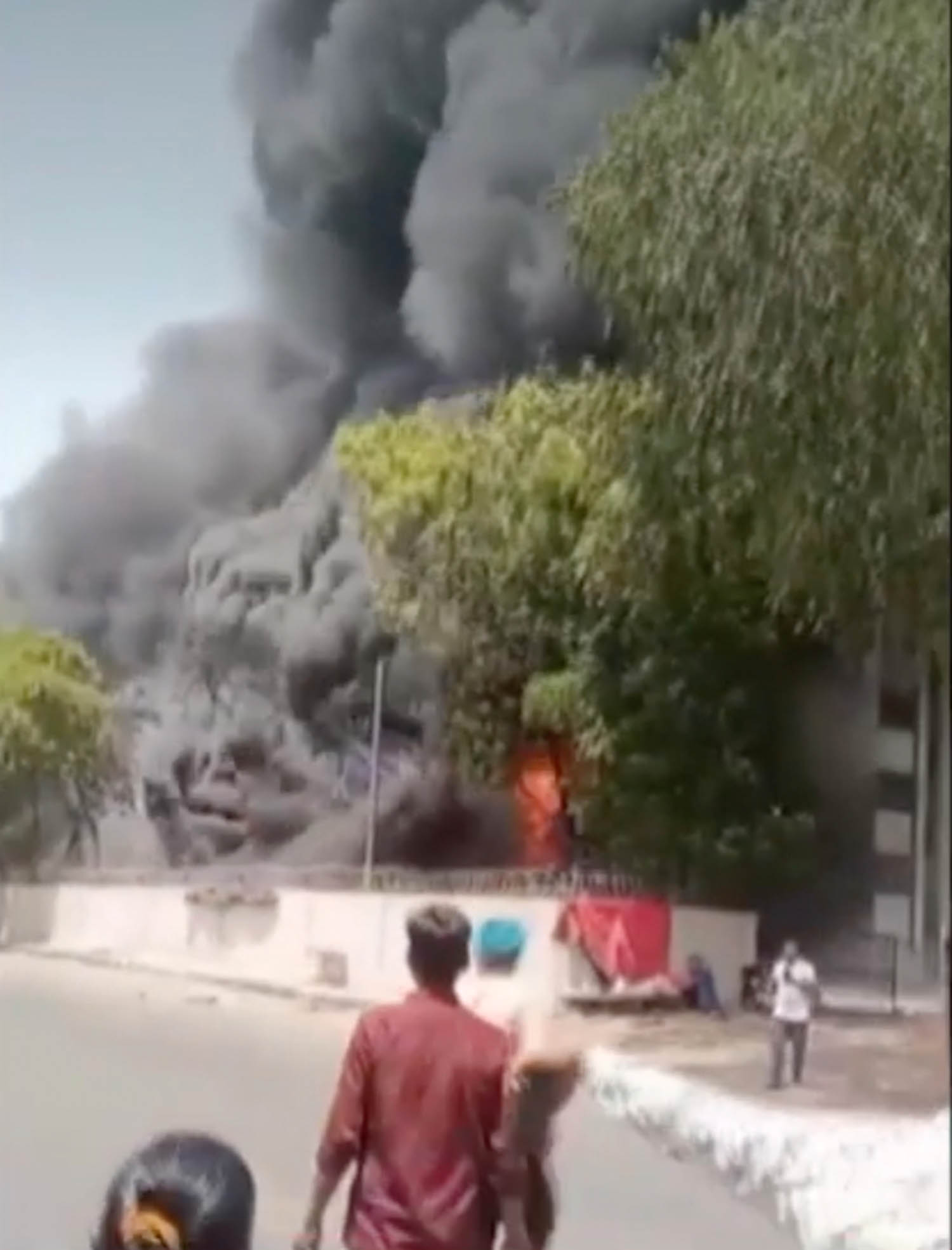 Vishwashkumar Ramesh, right, walks away from the Air India crash in Ahmedabad
