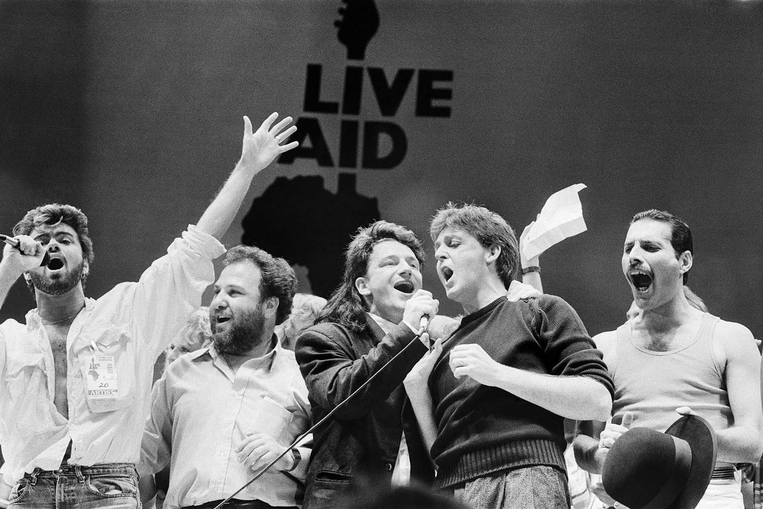 George Michael, Bono, Paul McCartney, Freddie Mercury and promoter Harvey Goldsmith on stage at Wembley