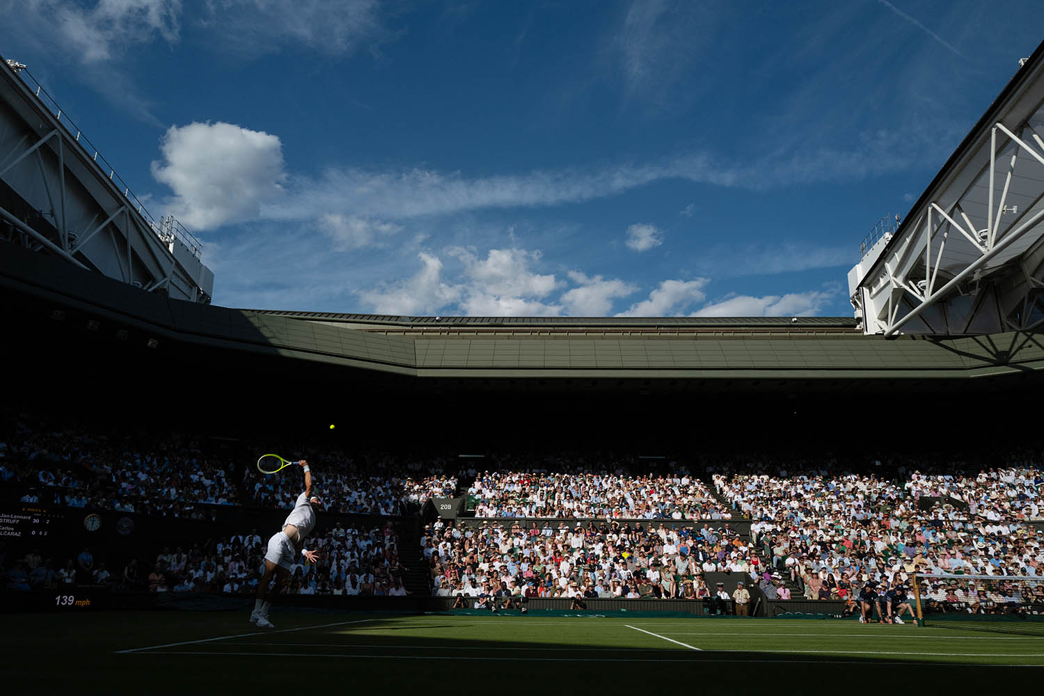 Jan Lennard-Struff serves against Alcaraz during their match on Centre Court