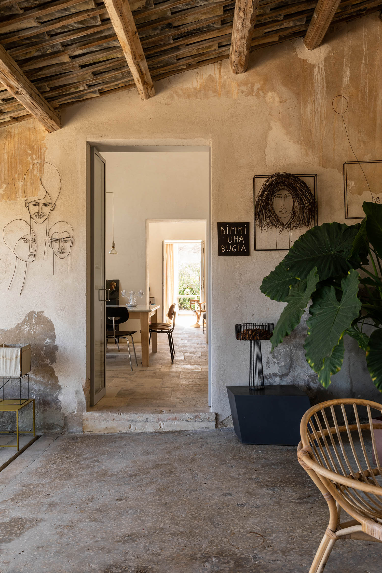 Outside the frame: portraits on either side of the back door welcome guests into the dining room