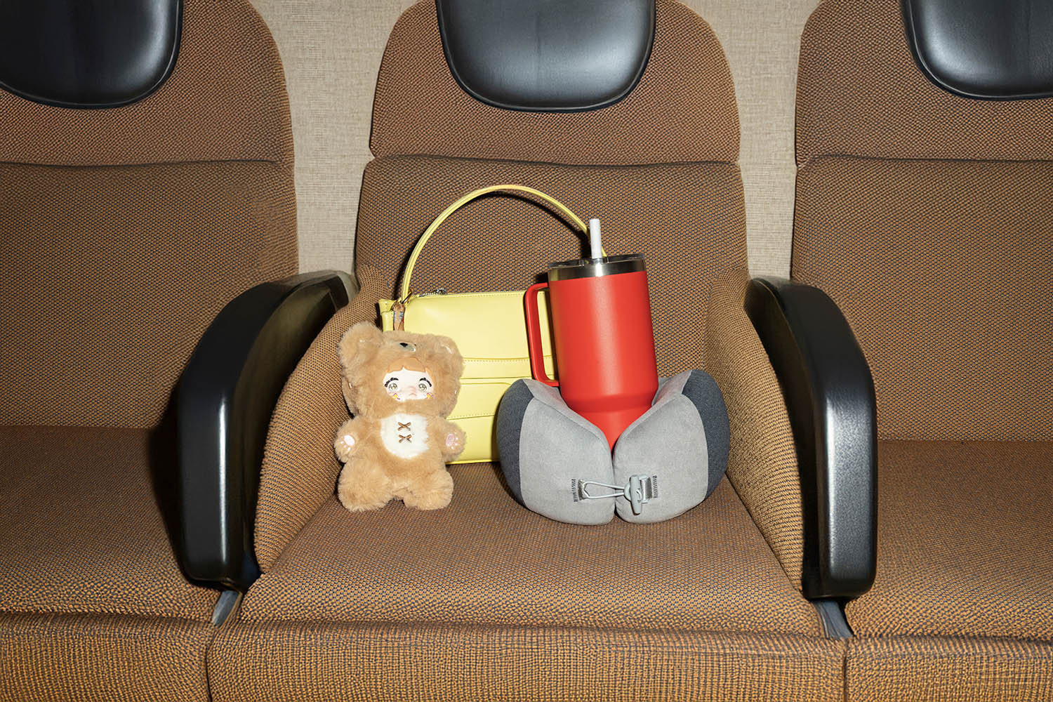 Loafer bag by JW Anderson; straw mug by Yeti; travel pillow by Boots