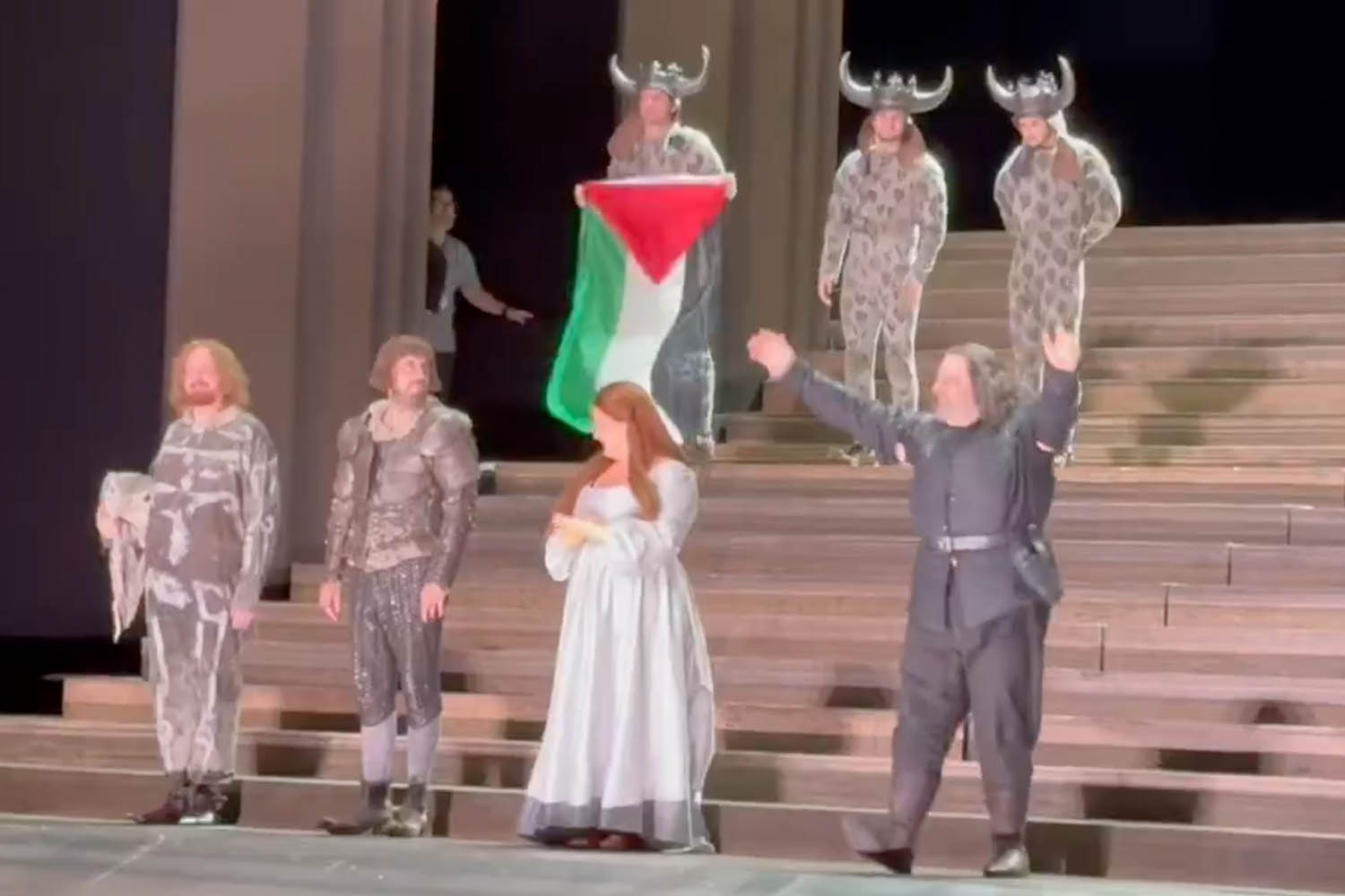 A cast member holds a Palestine flag after a Royal Opera House performance of Il Trovatore in July