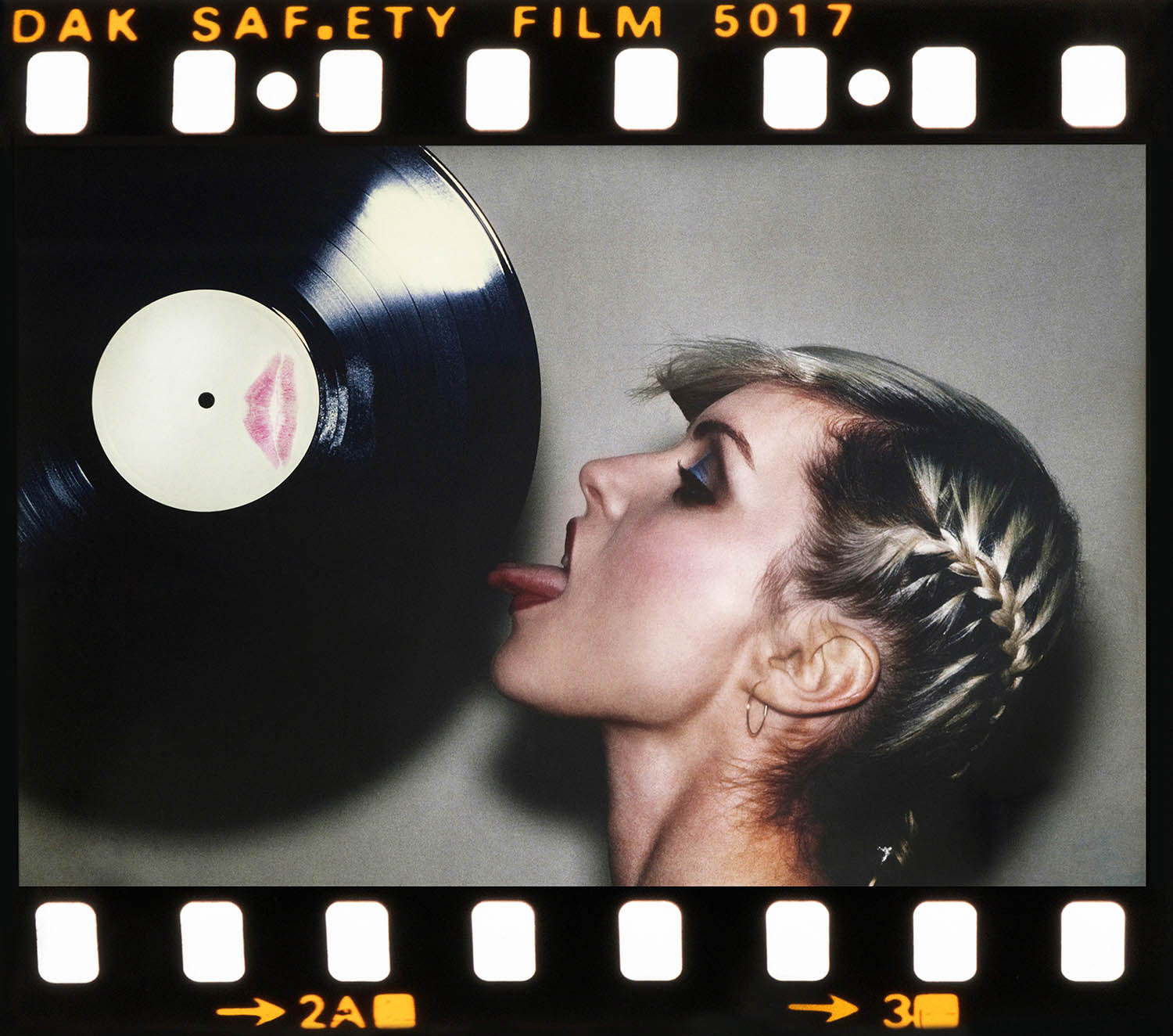 Harry licking the edge of a vinyl LP; this image was used for the cover of the single Picture This