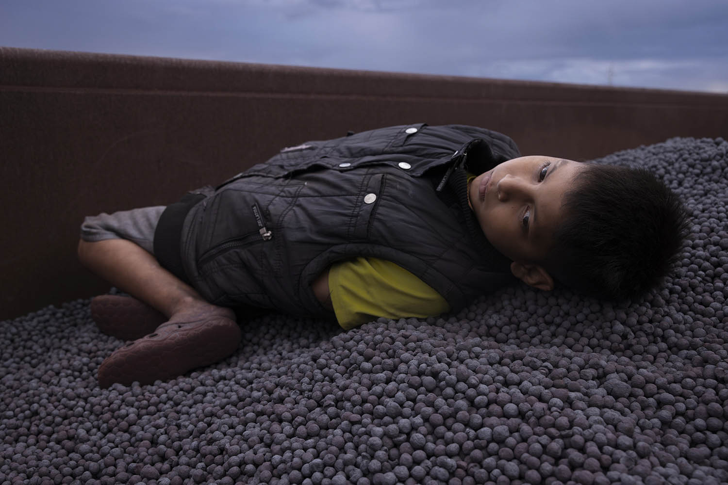 Jesus, 10, in a loaded wagon with iron pellets. He and his family are hoping to reach to US after a gang attacked their home in Ecuador