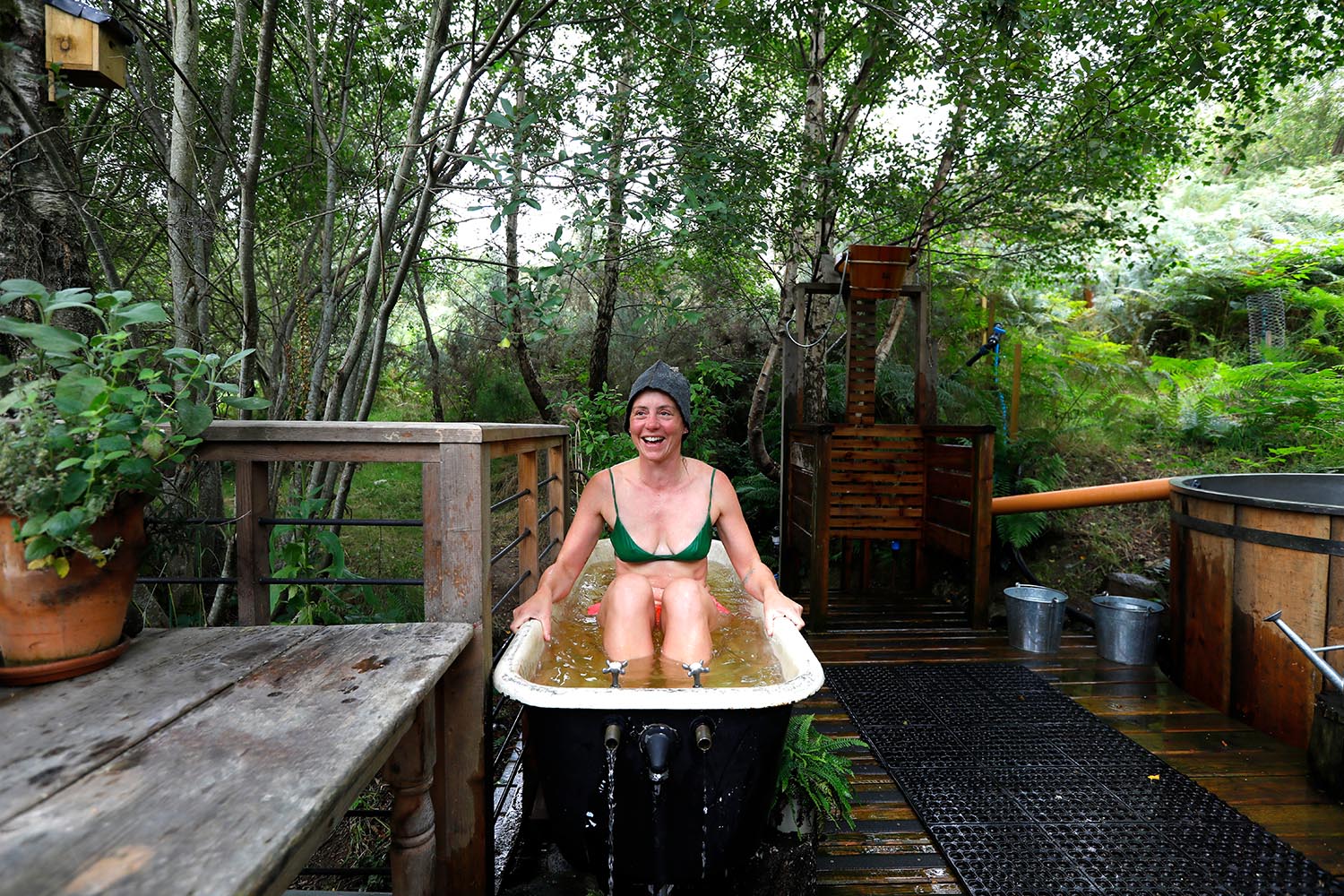 A bath filled with fresh river water accompanies a sauna at Comrie Croft campsite in Perthshire