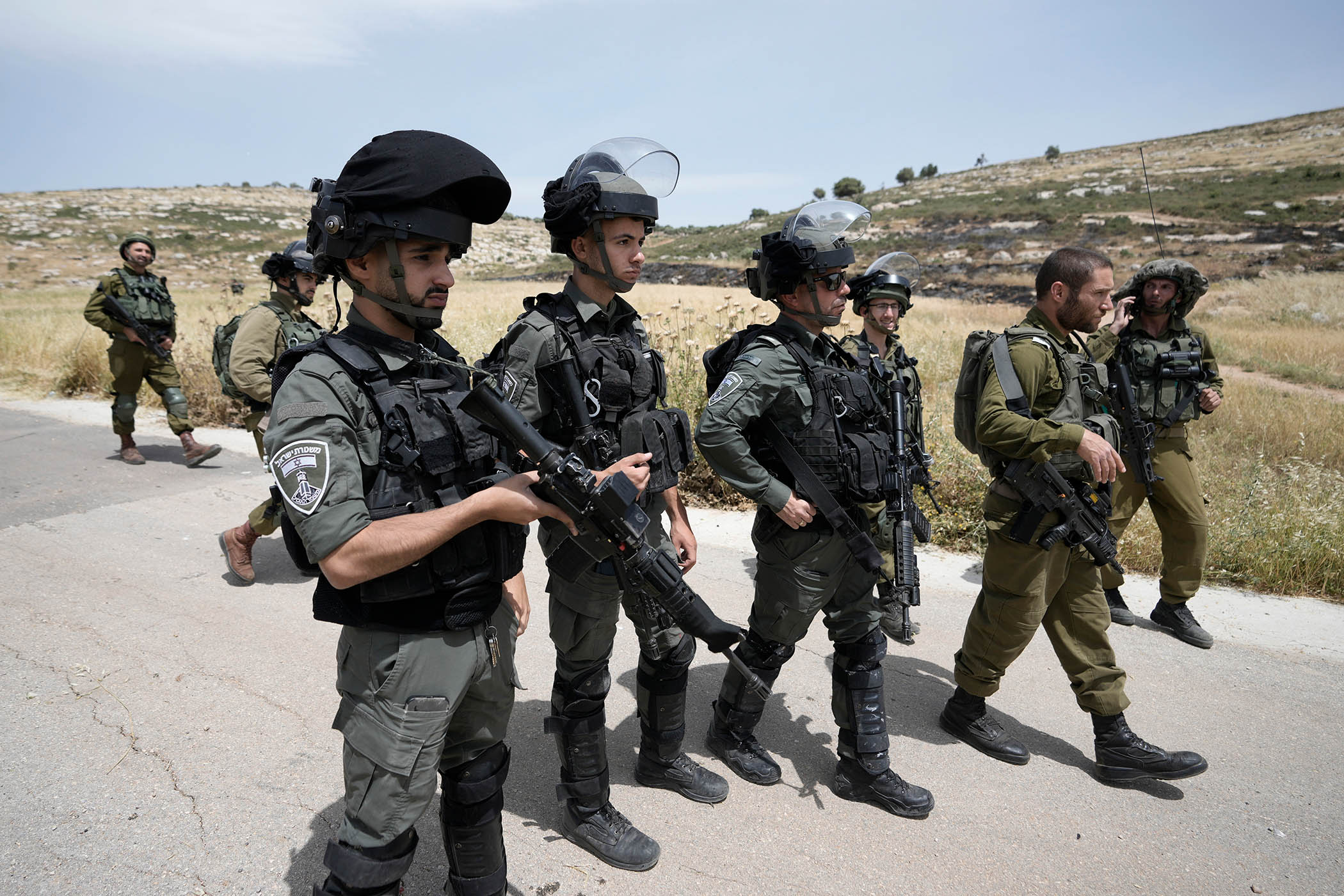 Israeli soldiers and border police at a site where settlers burned Palestinian cars and wheatfields in al-Mughayyir in May 2023