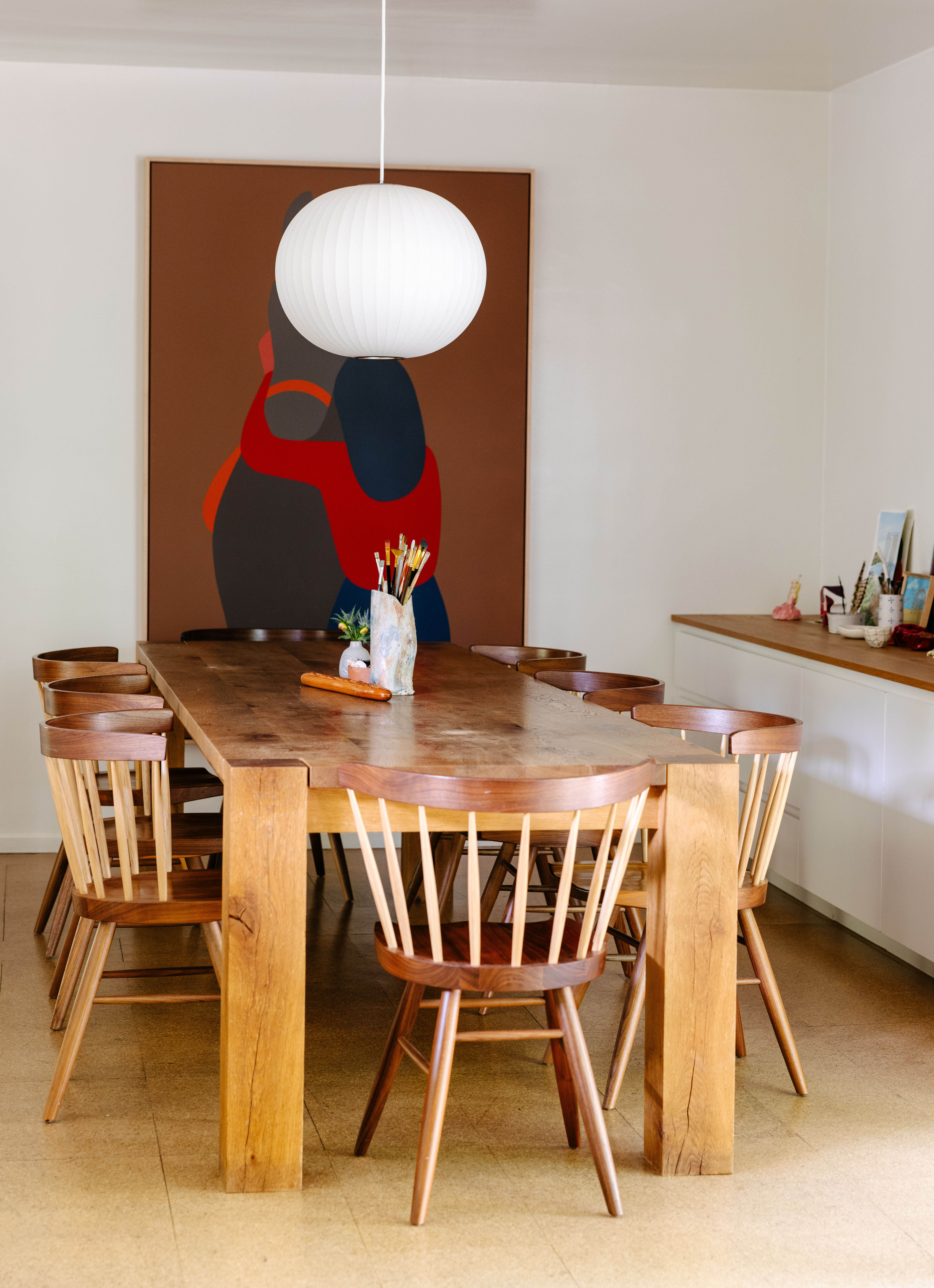The dining area is dominated by a long, sturdy dining table by the German brand e15