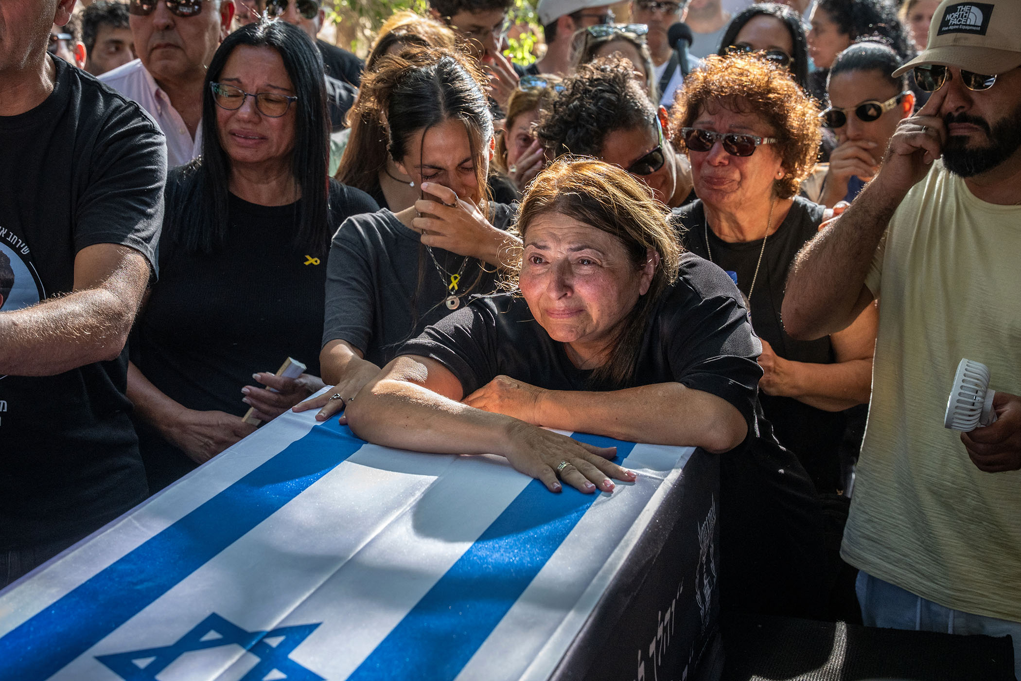 As the living hostages return home, a long wait continues for the families of the dead
