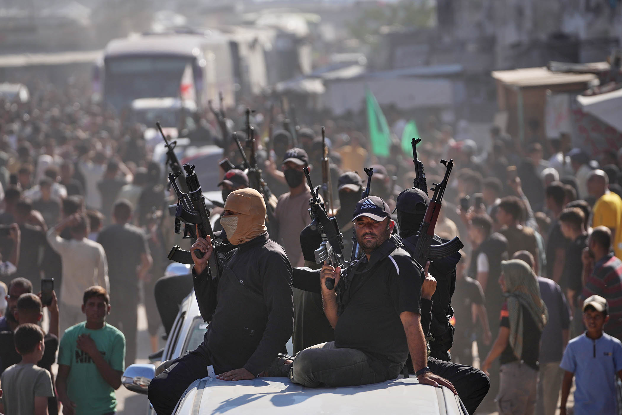 Hamas gunmen on pickup trucks escort buses carrying freed Palestinian prisoners in Khan Younis on Monday
