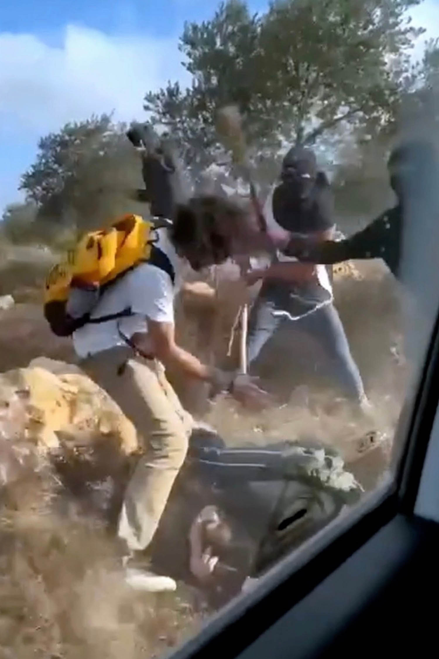 Image taken from a video of masked settlers beating Palestinian farmers in Turmus Ayya last weekend