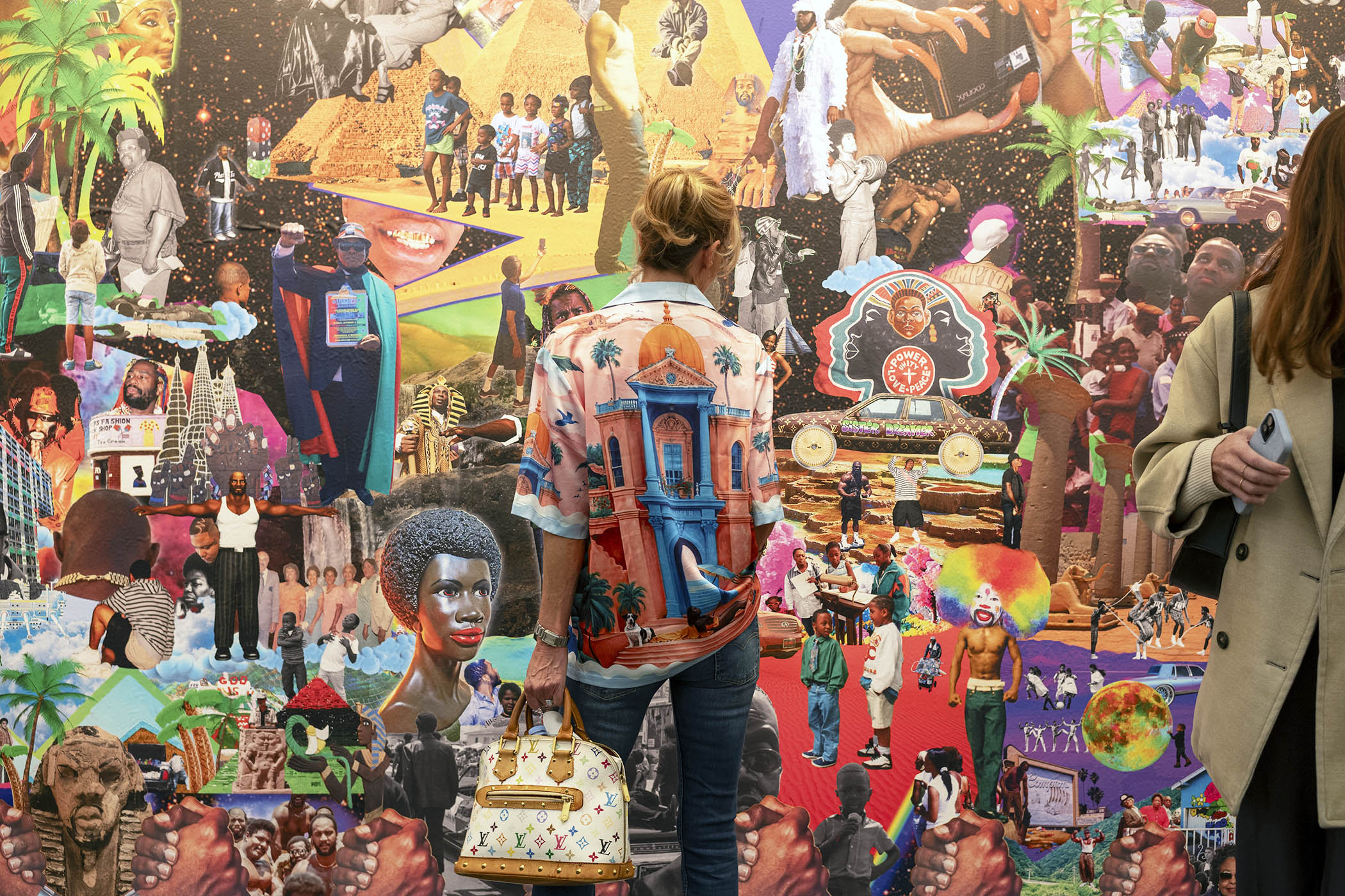 Life imitates art as a Frieze visitor views a colourful work by Lauren Halsey in the Gagosian booth