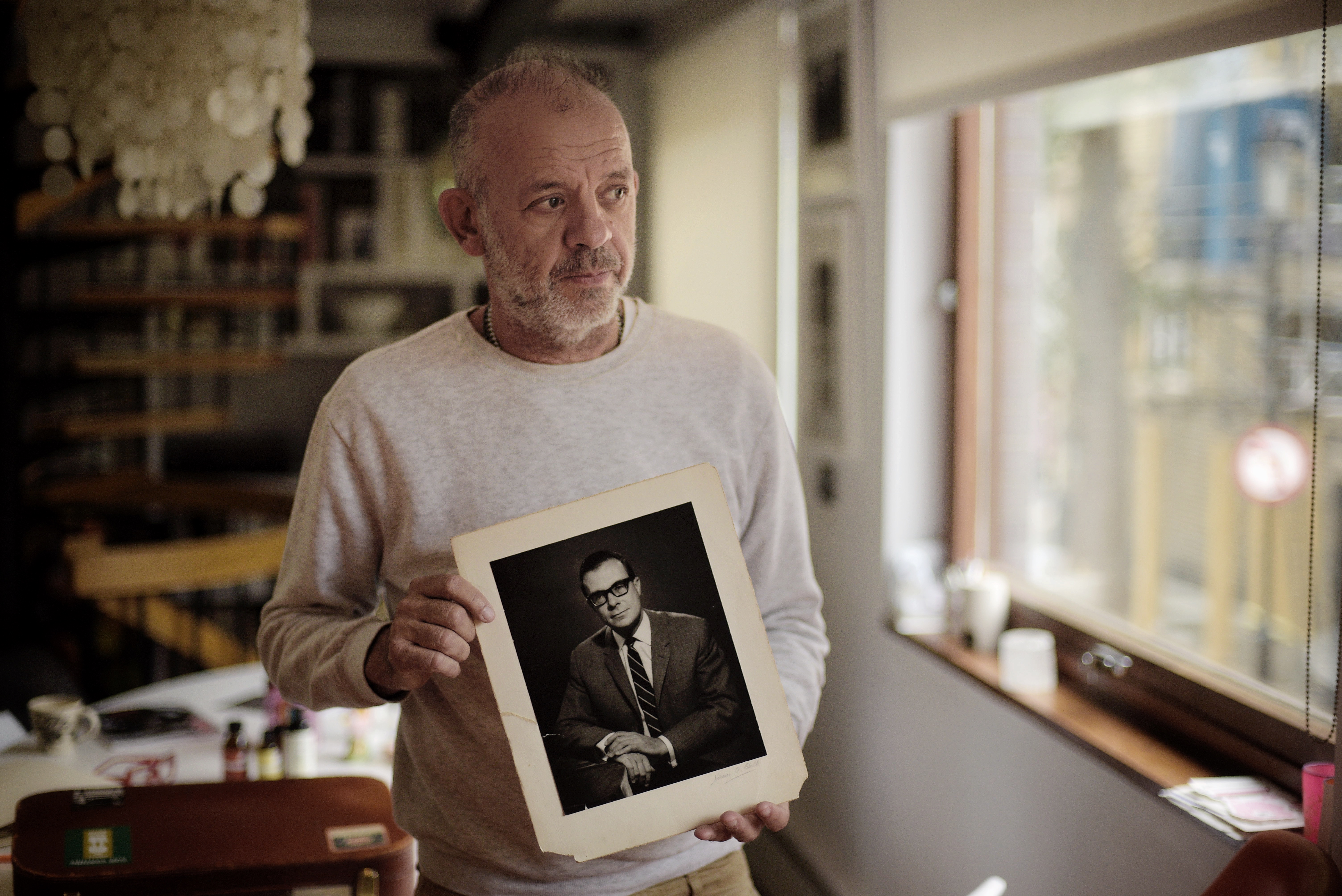 Antony Easton holding a photograph of his father Peter