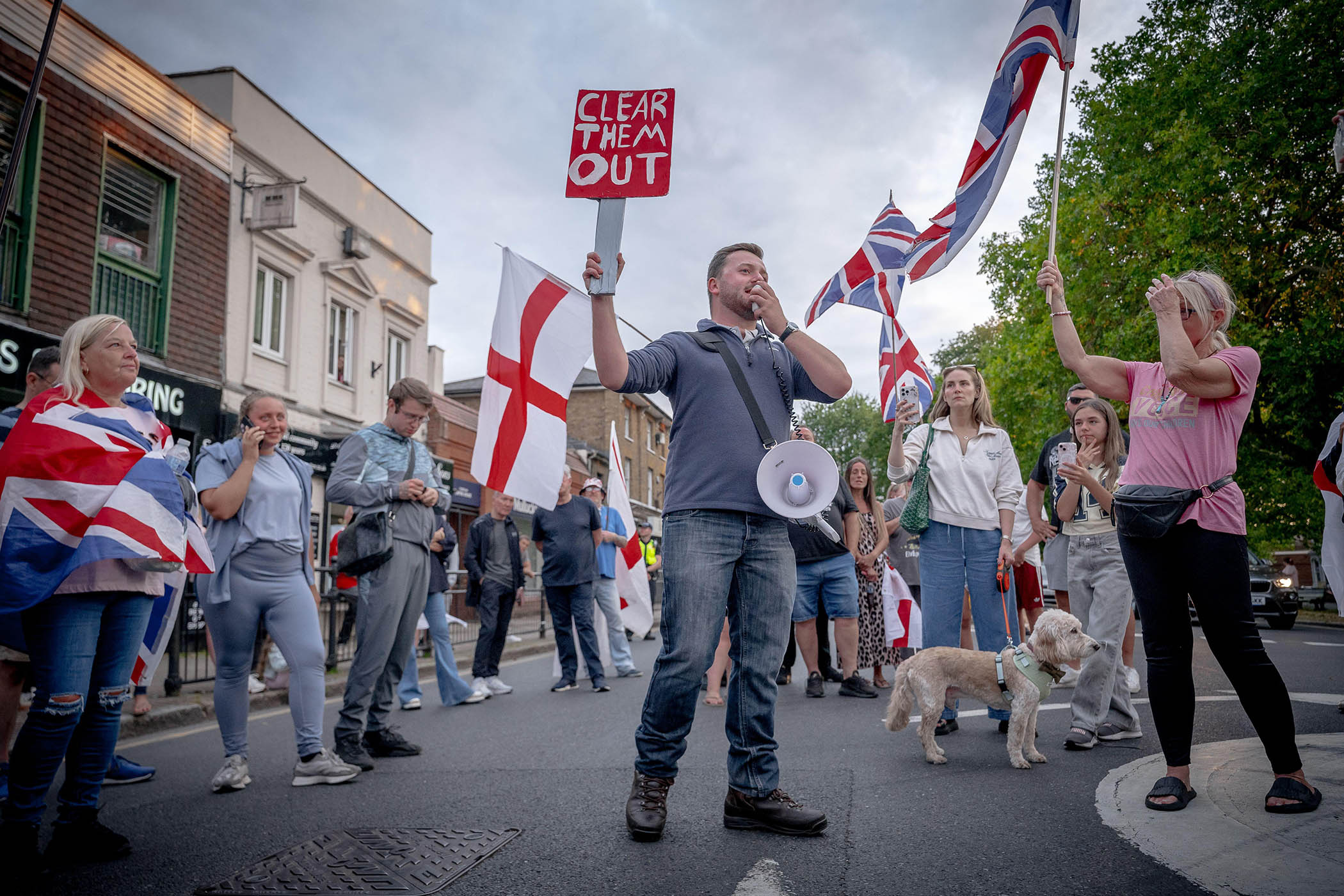 Callum Barker of Homeland Party speaks to anti-migrant protesters in Epping