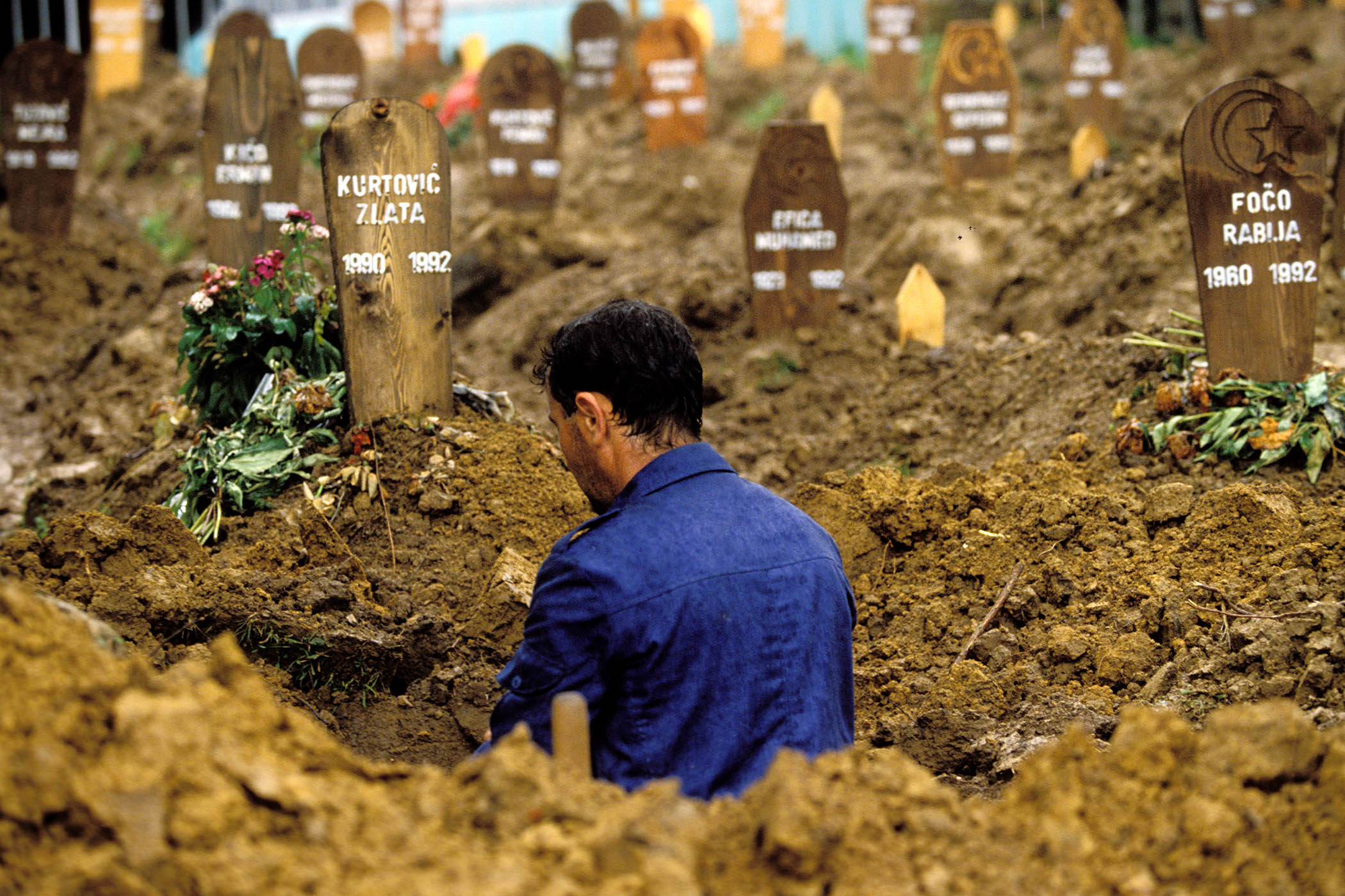 Above: man digs a child’s grave in a Sarajevo cemetery during the Bosnian War; lead picture: Biljana Plavšić at the ICTY in the Hague, January 2001.