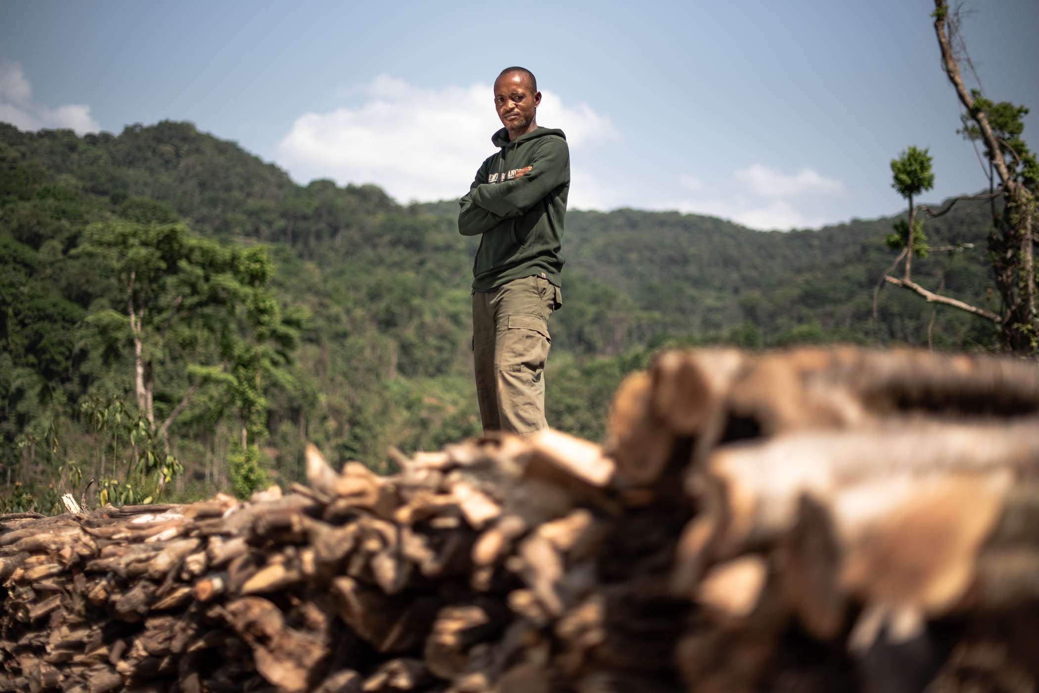 Ranger Prince Dumbaya and a pile of illegally felled wood