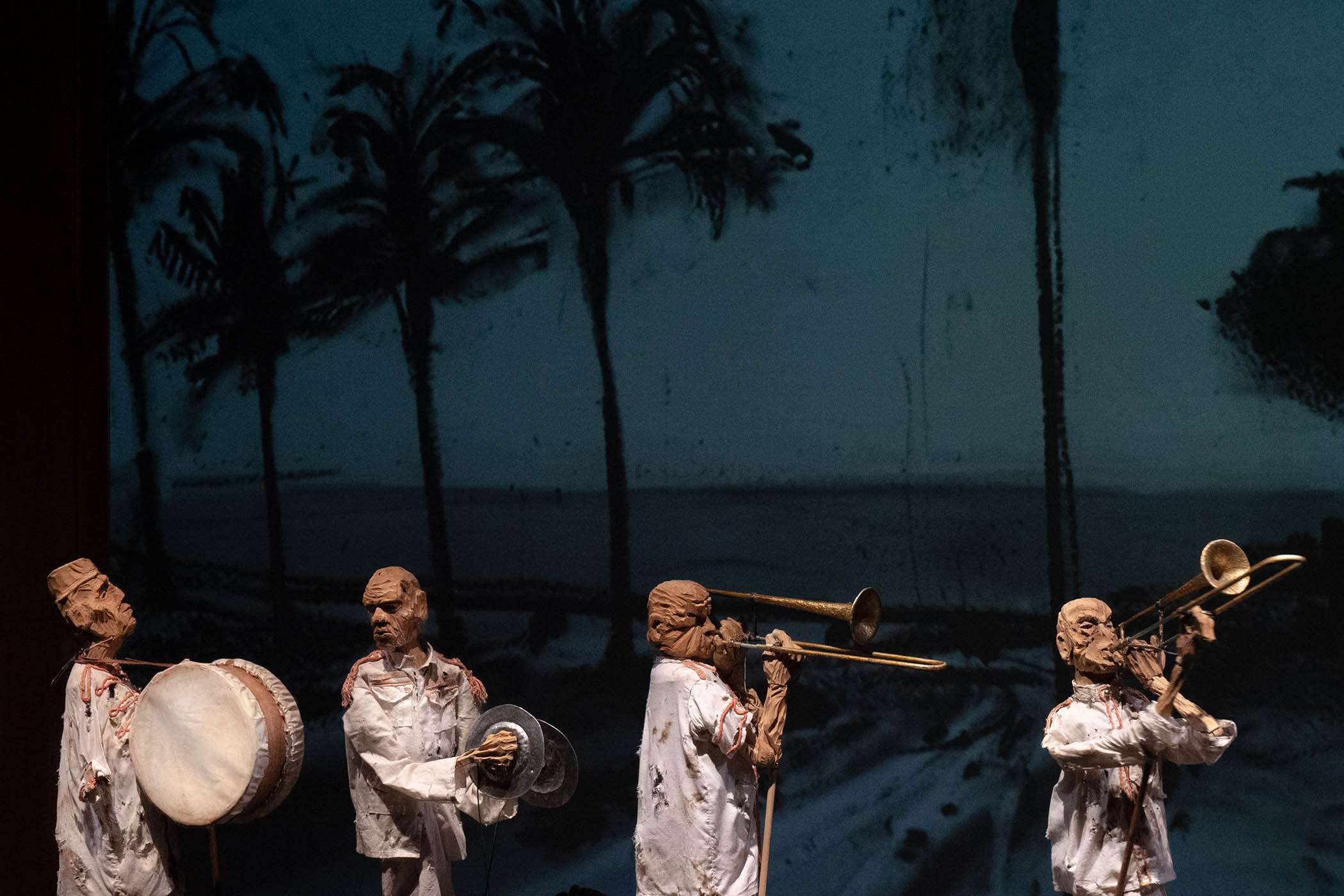 A marching band moves across the stage before Kentridge’s own tremendous charcoal backdrop