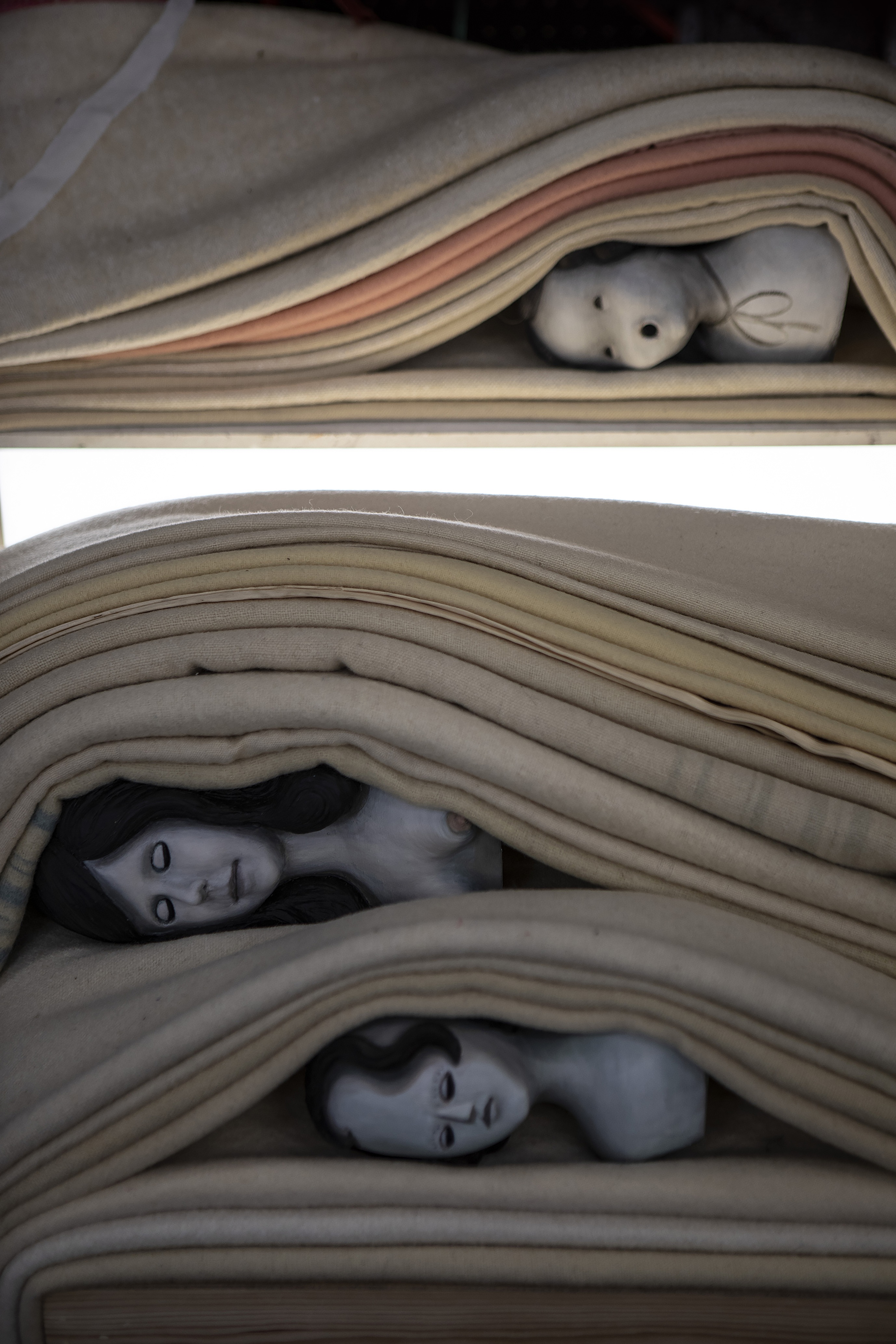 Cathie Pilkington’s Strata contains sculptural heads ‘piled under layers of fabric that imitate a geological cross-section’