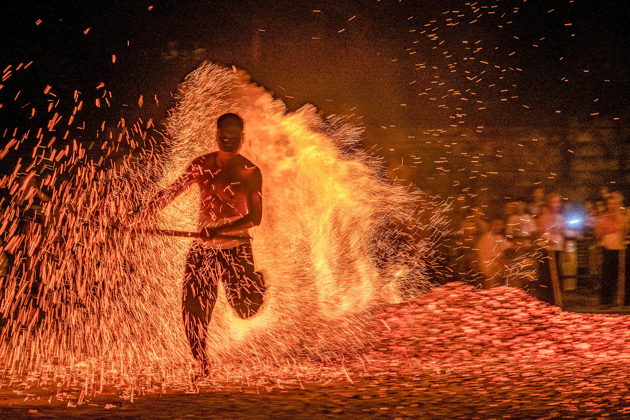 A villager walks over burning charcoal in a traditional ritual at Shuangfeng village in Jinhua