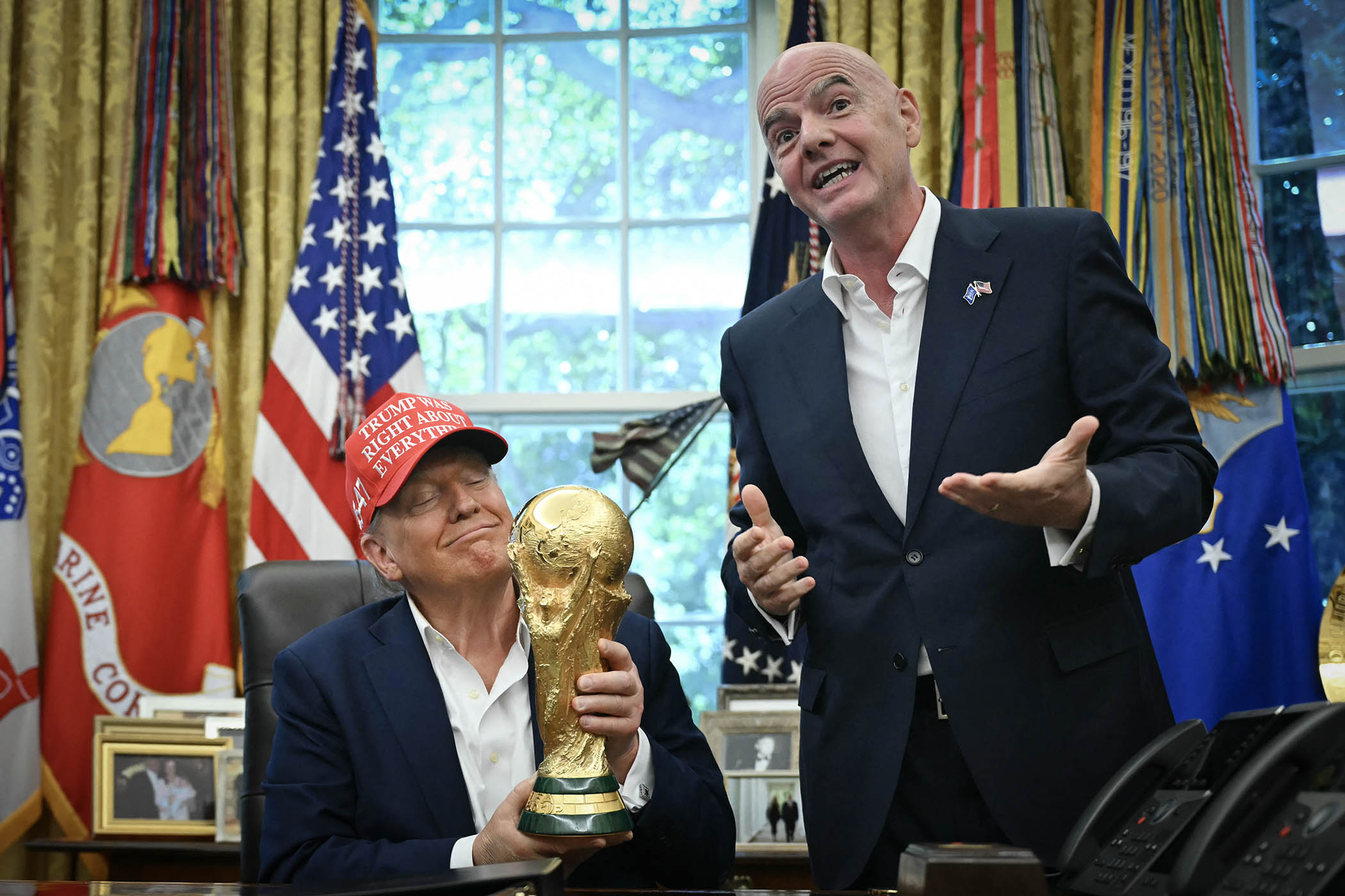Donald Trump holds the World Cup trophy next to Fifa president Gianni Infantino in the Oval Office of the White House.