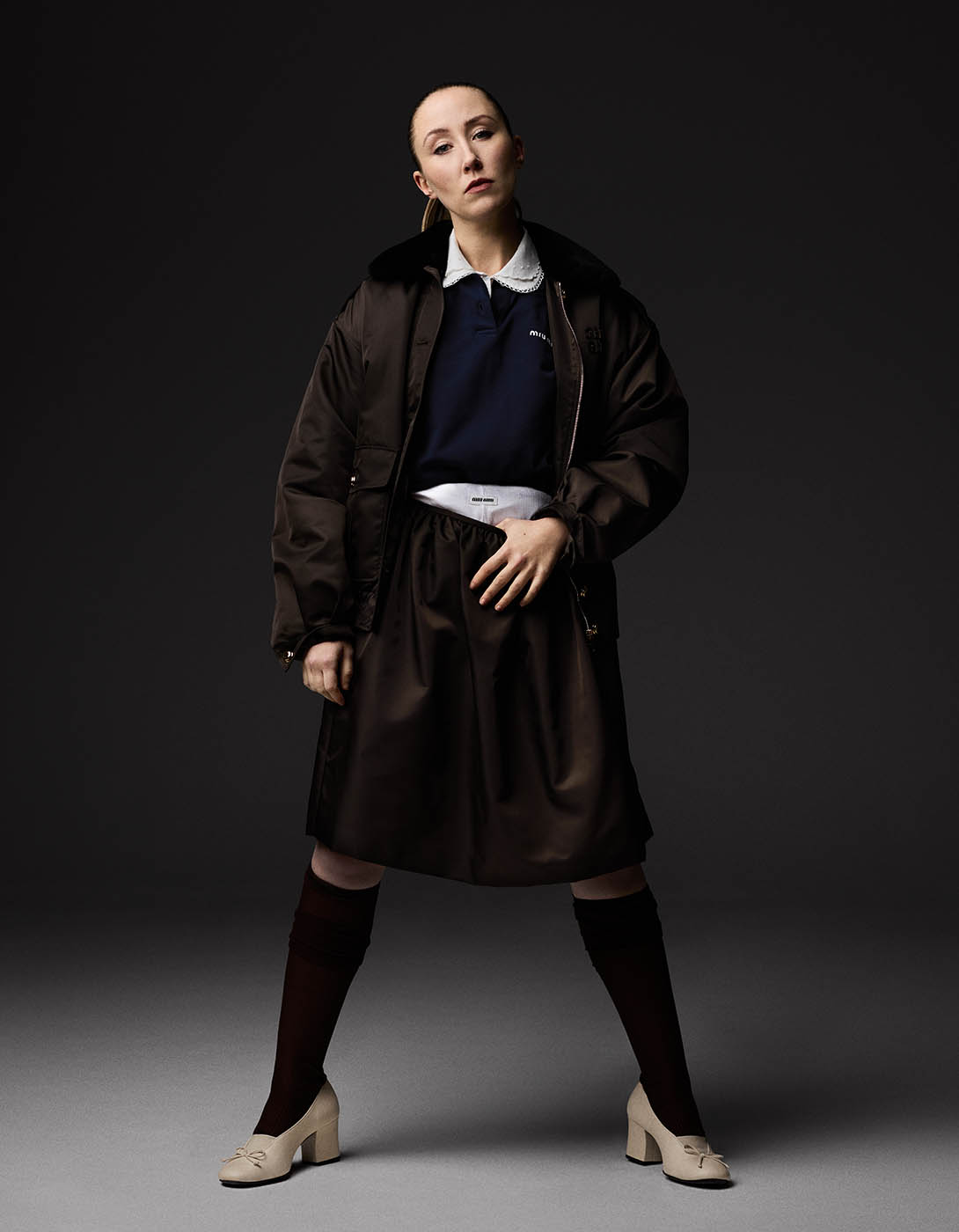Nylon jacket, poplin shirt, navy polo, skirt, ribbed silk socks and white pumps, all by Miu Miu