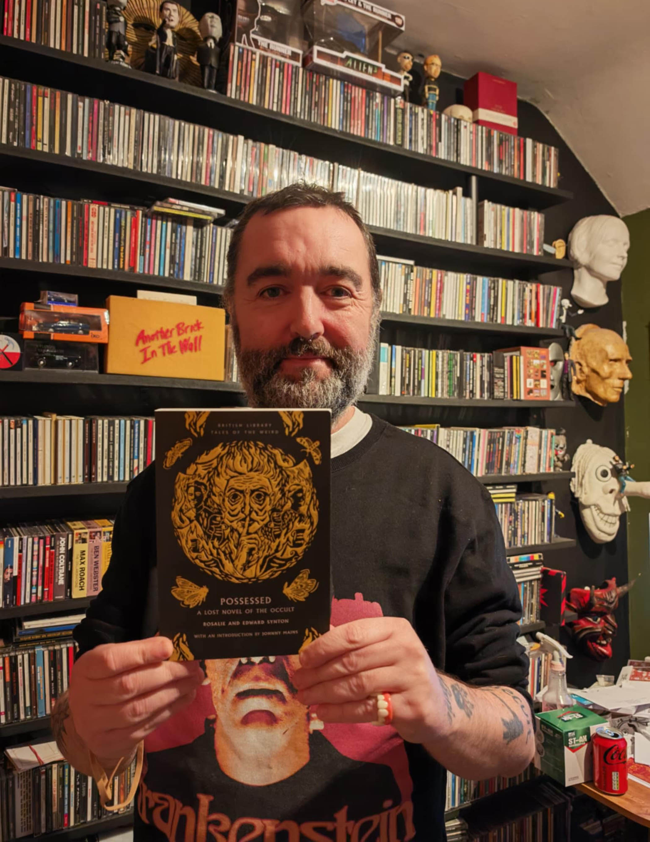 Fantasy author Johnny Mains holds up his novel, Possessed