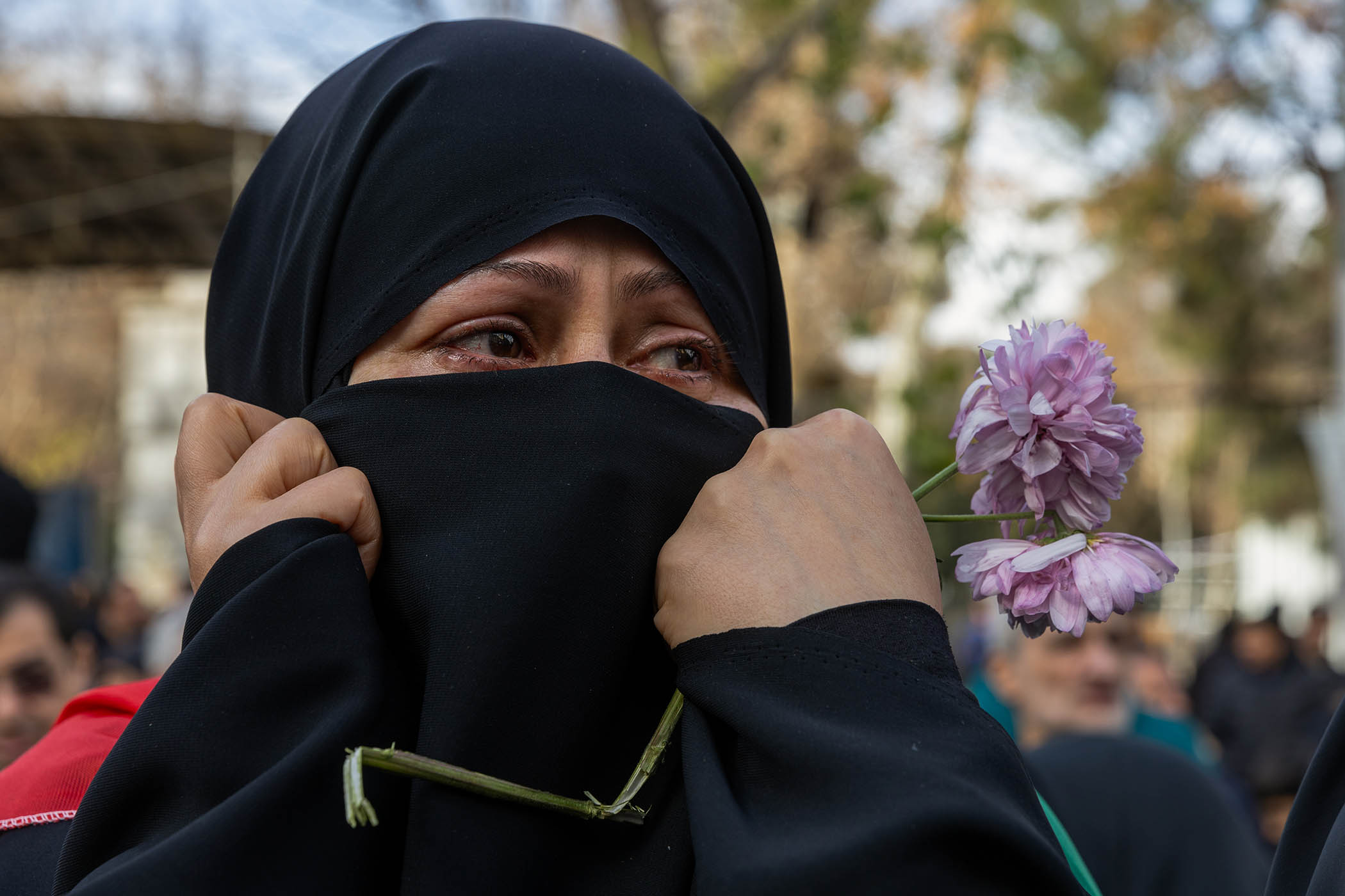 A woman attends a funeral ceremony held for more than 100 security personnel alleged to have been killed during nationwide unrest