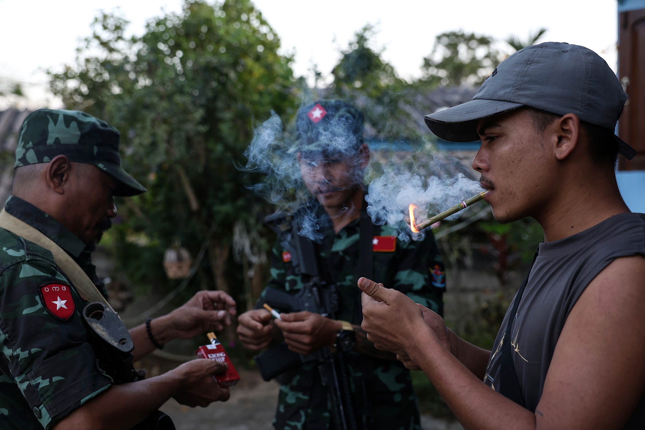 Rebel fighters light cigars in Mawdaung