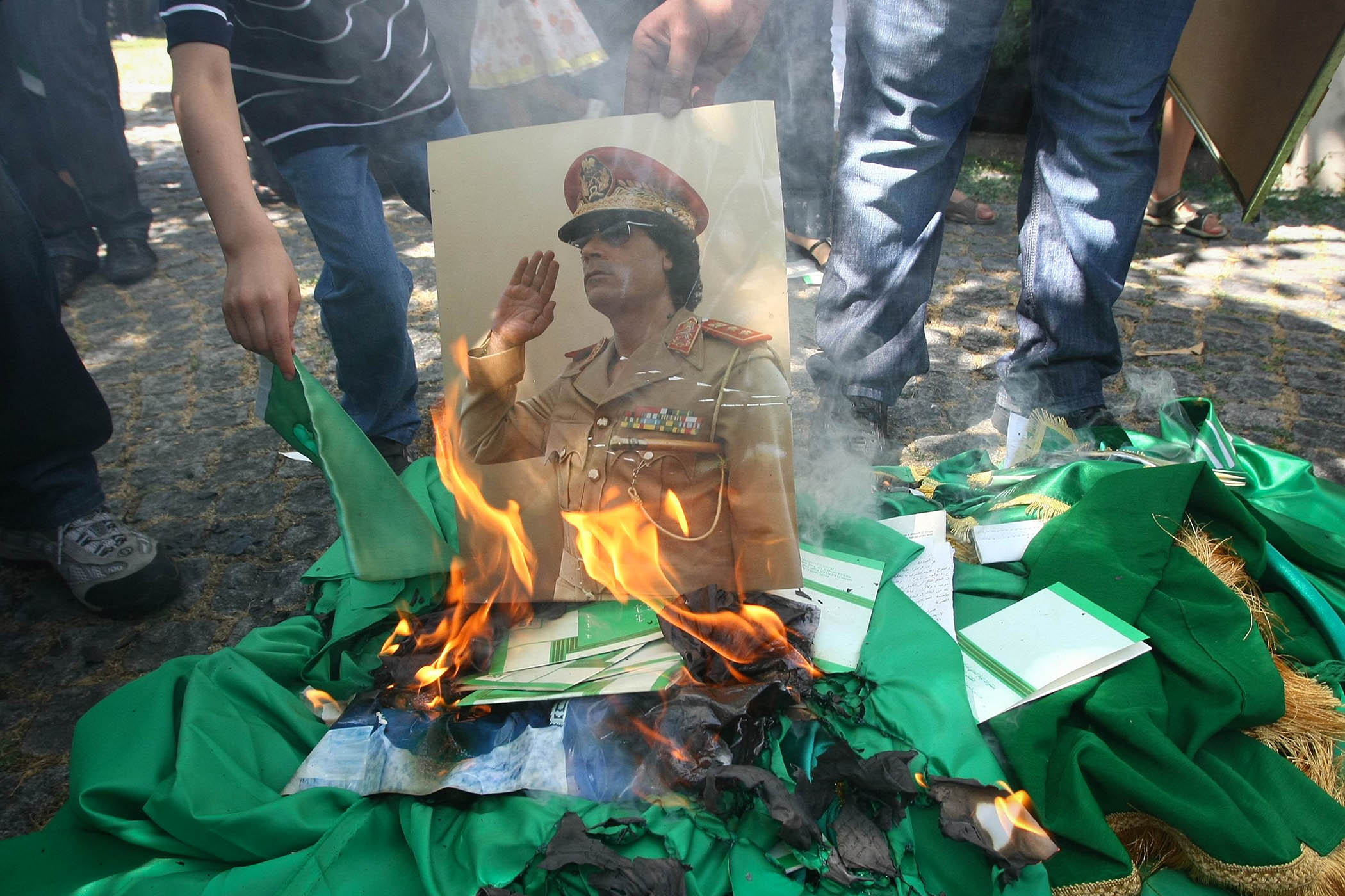 Protesters set fire to a picture of Muammar Gaddafi in 2011